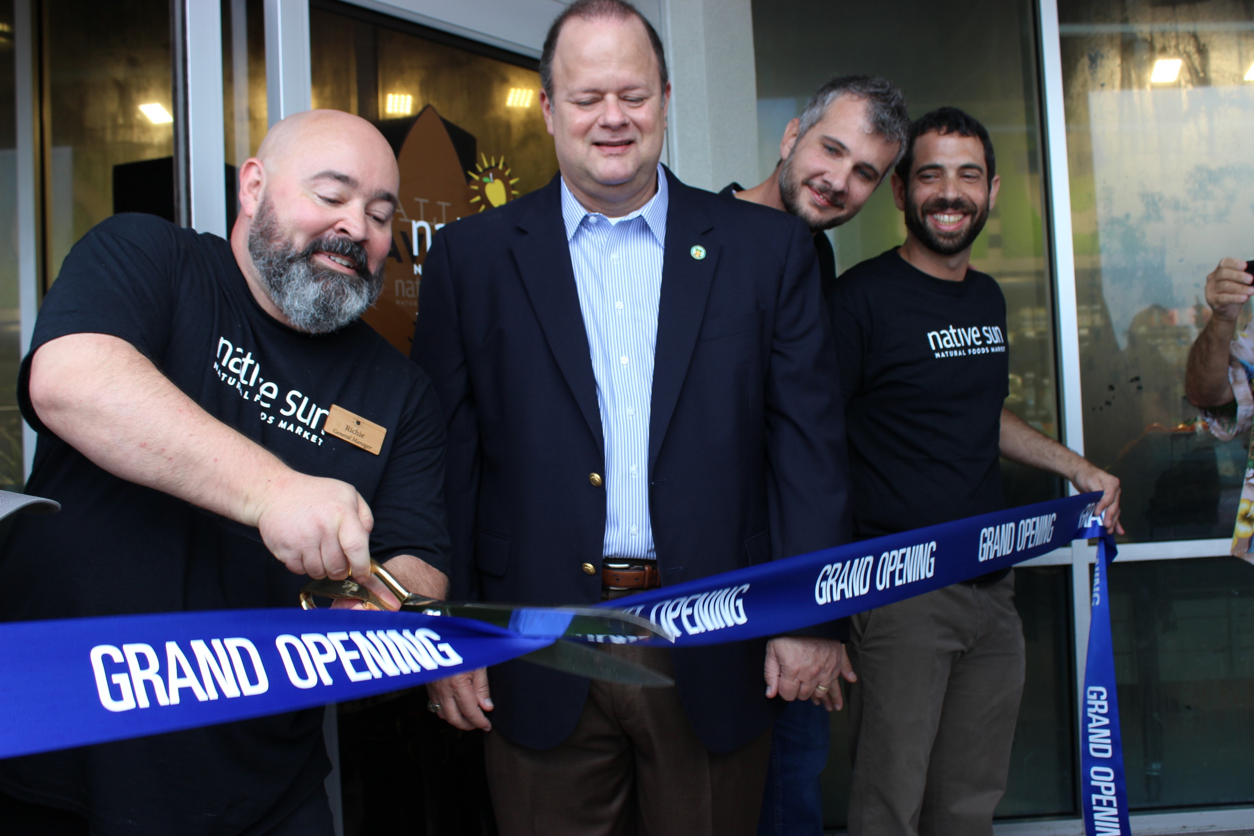 Native Sun Jacksonville Beach General Manager Richie Whitson cuts the ribbon at the grand opening of the new store while Jacksonville Beach Mayor Charlie Latham and Native Sun founder, Aaron Gottlieb (far right) look on.