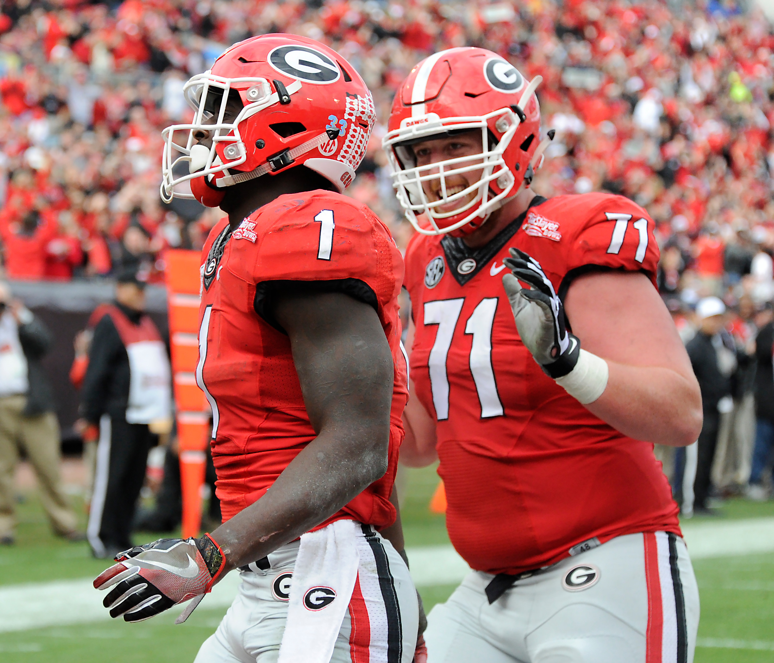 Georgia offensive lineman John Theus (71) from Jacksonville congratulates tailback Sony Michel (1) on his TD against the Penn State in the TaxSlayer Bowl.