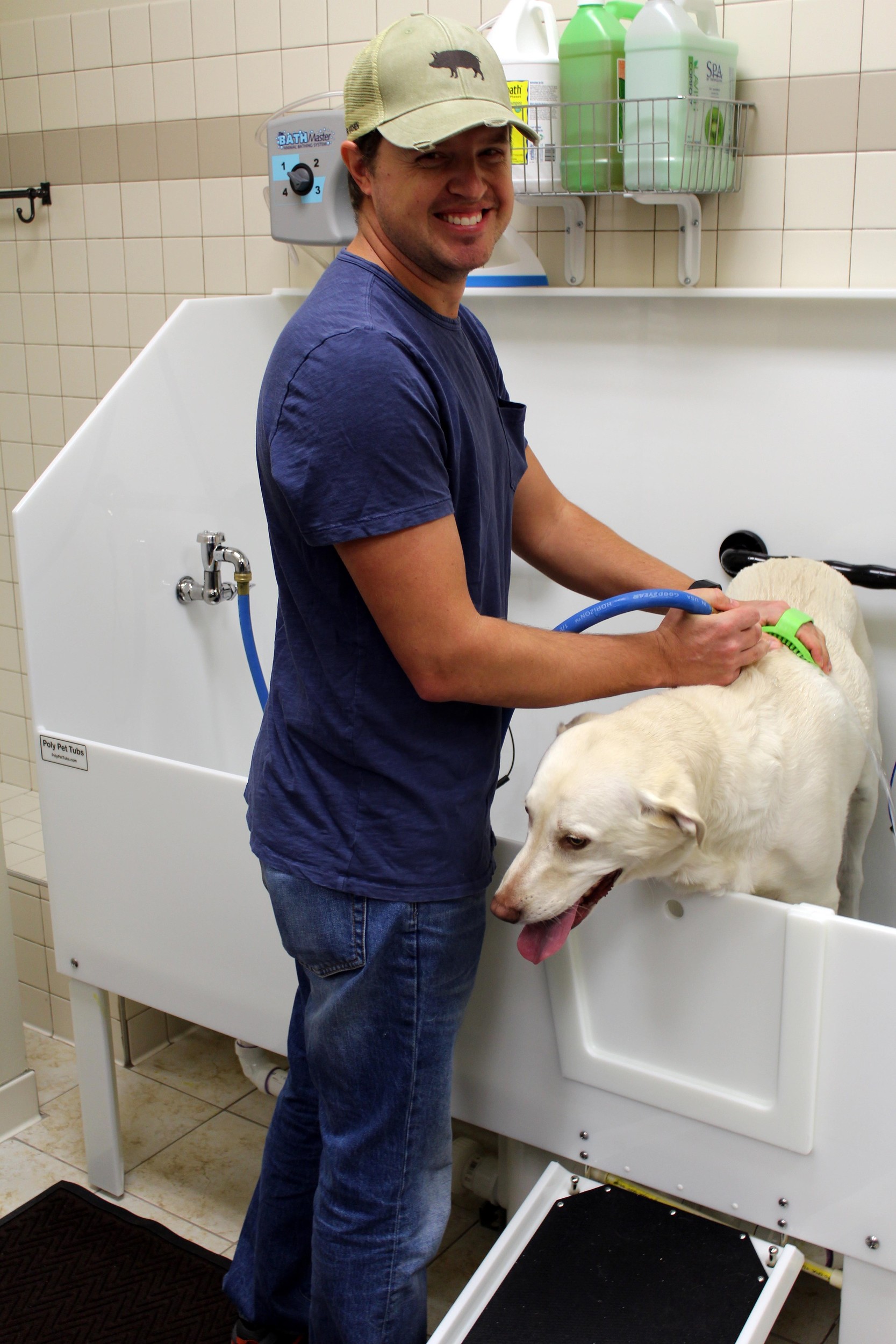 Winston Sheen of Ponte Vedra washes his dog, Remi, at one of EarthWise Pet’s self-wash stations. The store recently opened in Jacksonville Beach.