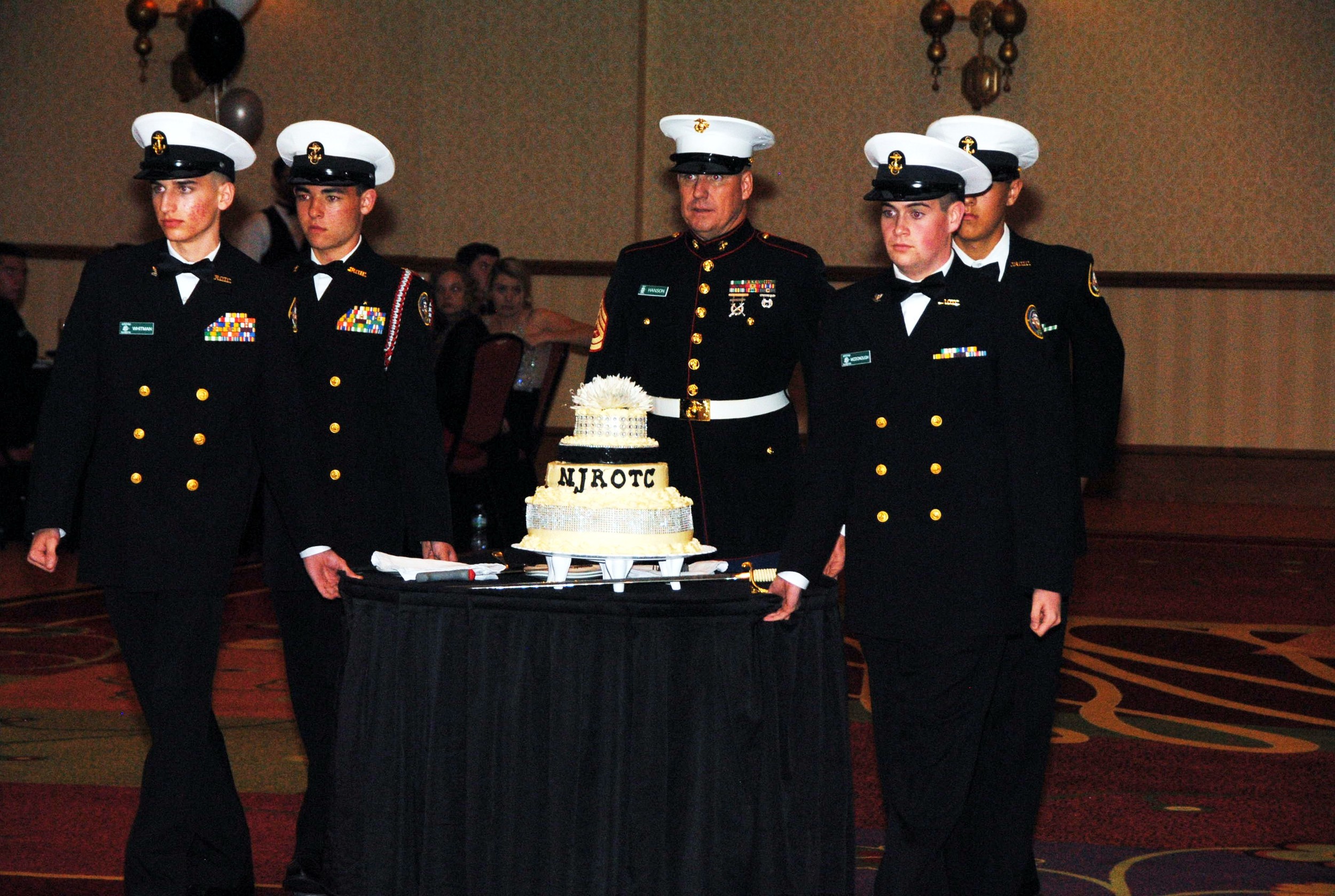 Nease NJROTC cadets (left to right) Chris Gilmer, Chris McDonough, Alex DeRoven and Preston Whitman formally present the cake under the direction of Gunnery Sergeant Duane Hanson during the 23rd annual Navy Ball.
