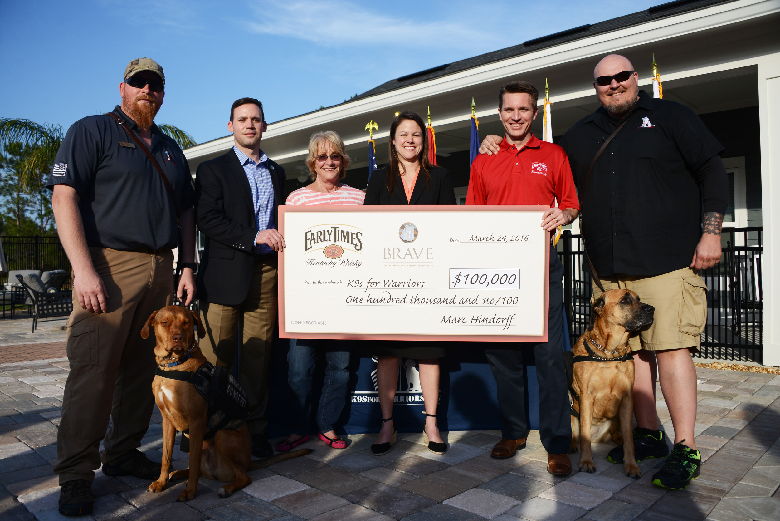 K9s for Warriors Founder Shari Duval and Executive Director Rory Diamond accept a $100,000 donation from Early Times Kentucky Whisky. From left:  K9s for Warriors graduate Greg Wells and his service dog, Utah; Diamond; Duval; Robin Nicholson of Early Times parent company Brown-Forman; Early Times’ Marc Hindorff; and and K9s Graduate Joe Swoboda and his service dog Lilly.
