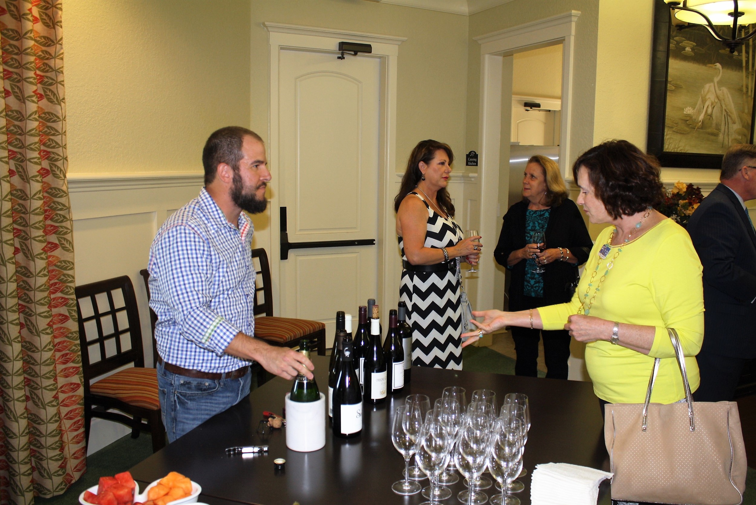 Re/Max Realtor Cindy Spain discusses wine with Coastal Wine Market & Tasting Room Owner Steve Lourie