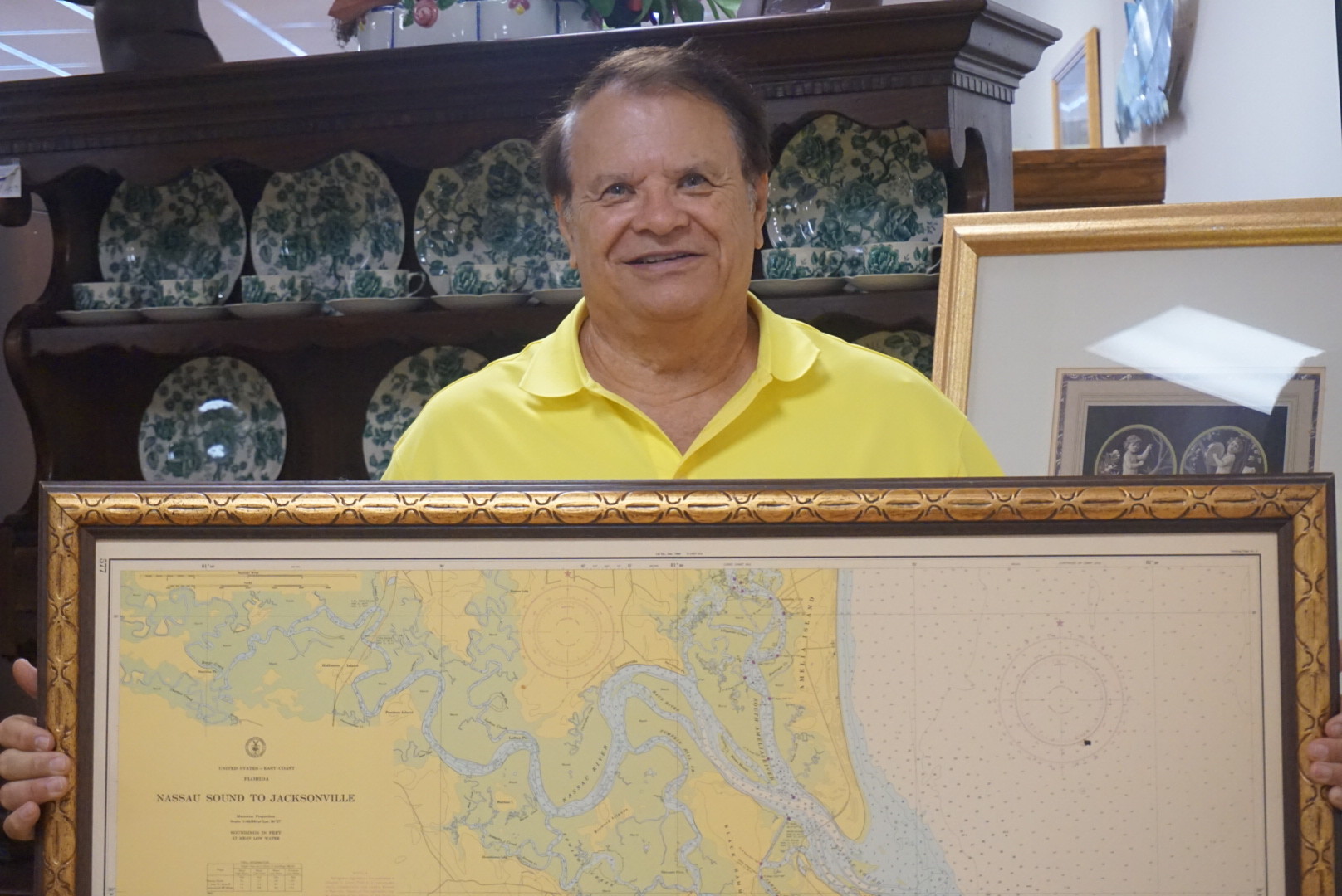 First Coast Antique’s Richard Mette, an Antiques & More Consignment dealer, poses with a vintage map of Nassau Sound.