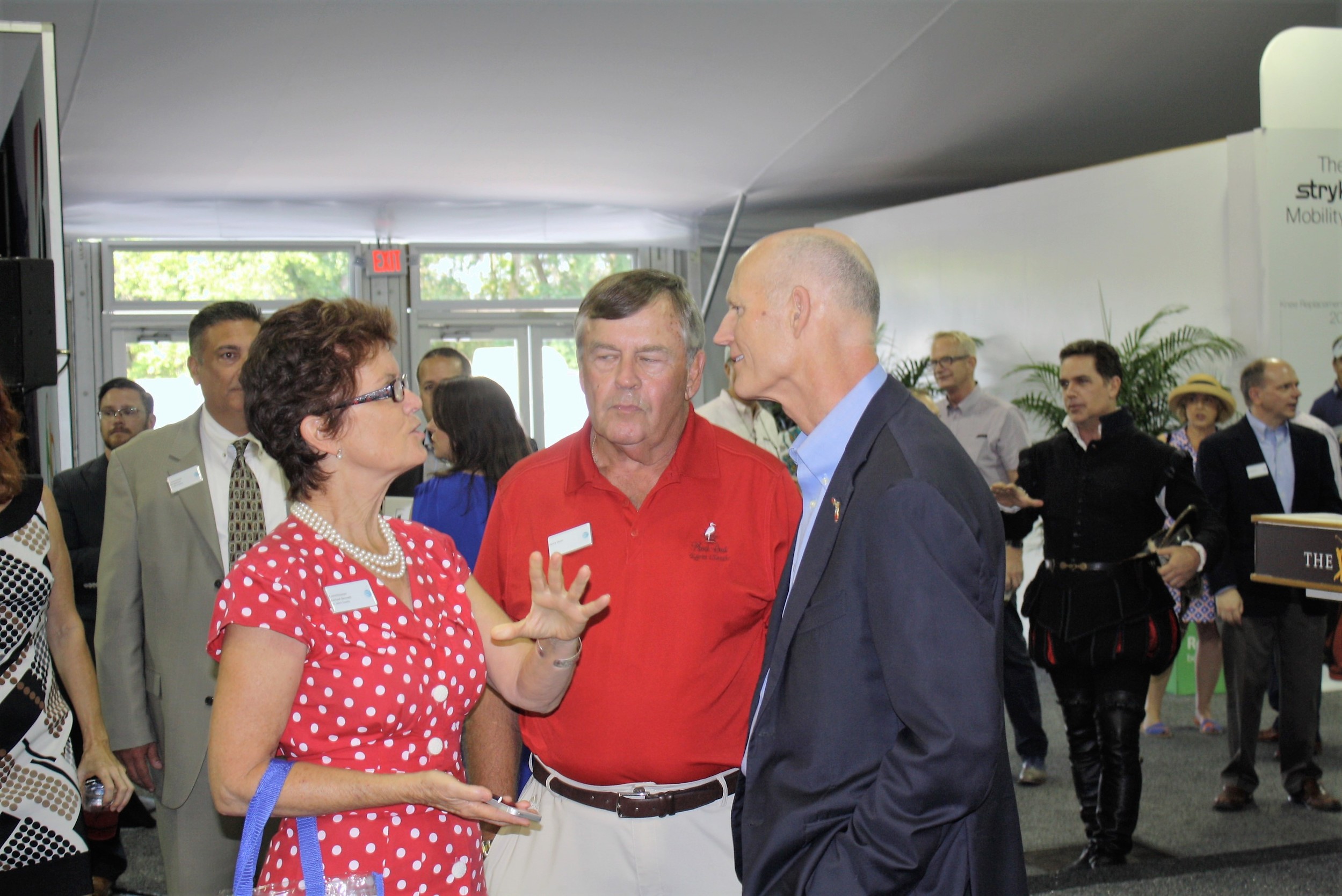 County Commissioner Rachael Bennett and Henry Deen speak with Governor Rick Scott.