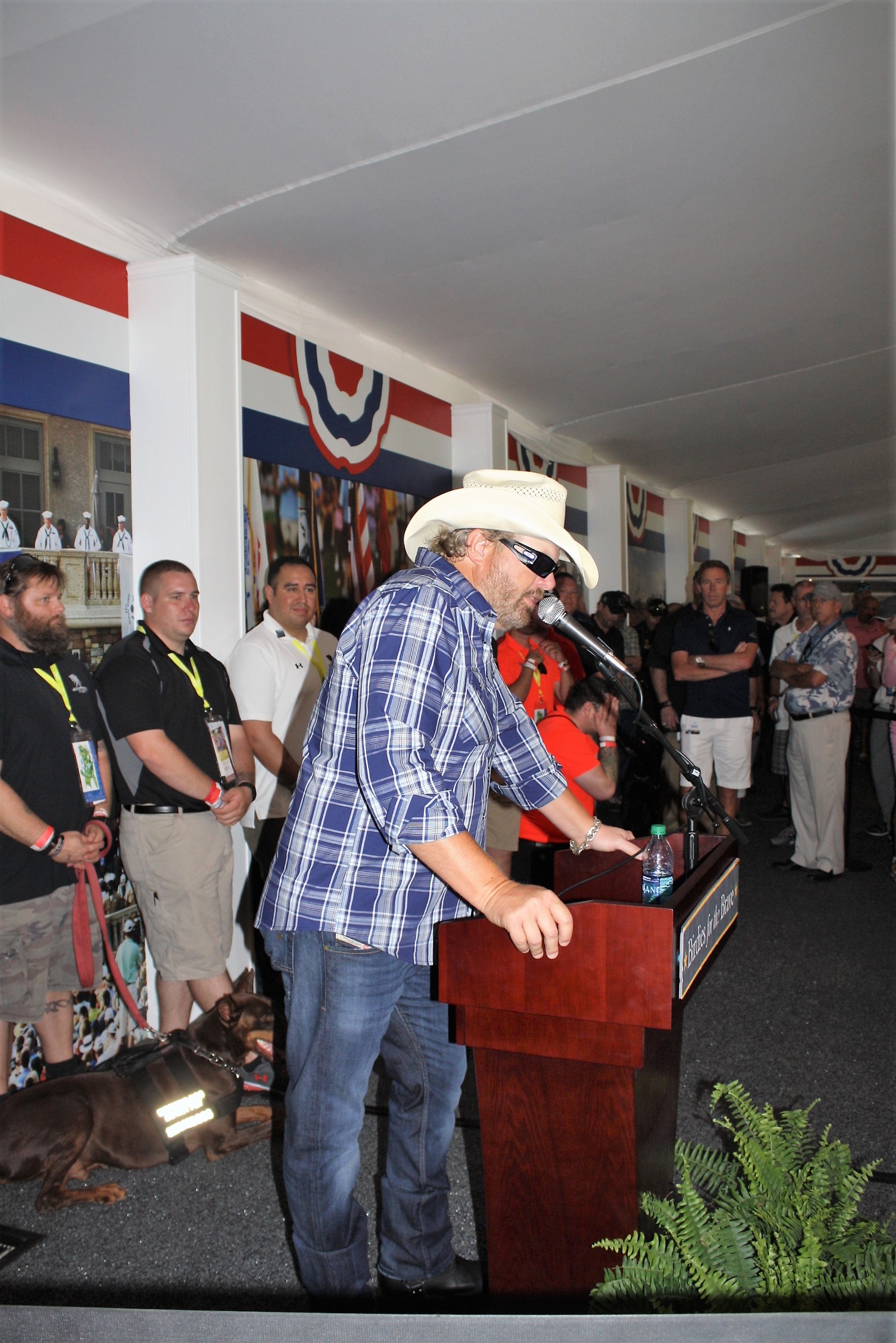 Country Music Star Toby Keith addresses guests at the Birdies for the Brave Patriots’ Outpost as representatives from K9s for Warriors look on