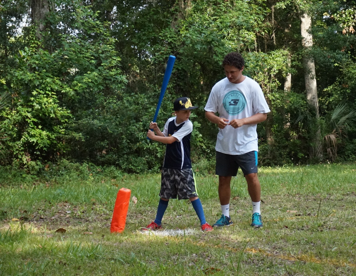 Counselor Alex Awad gives Clayton Payne tips before his swing