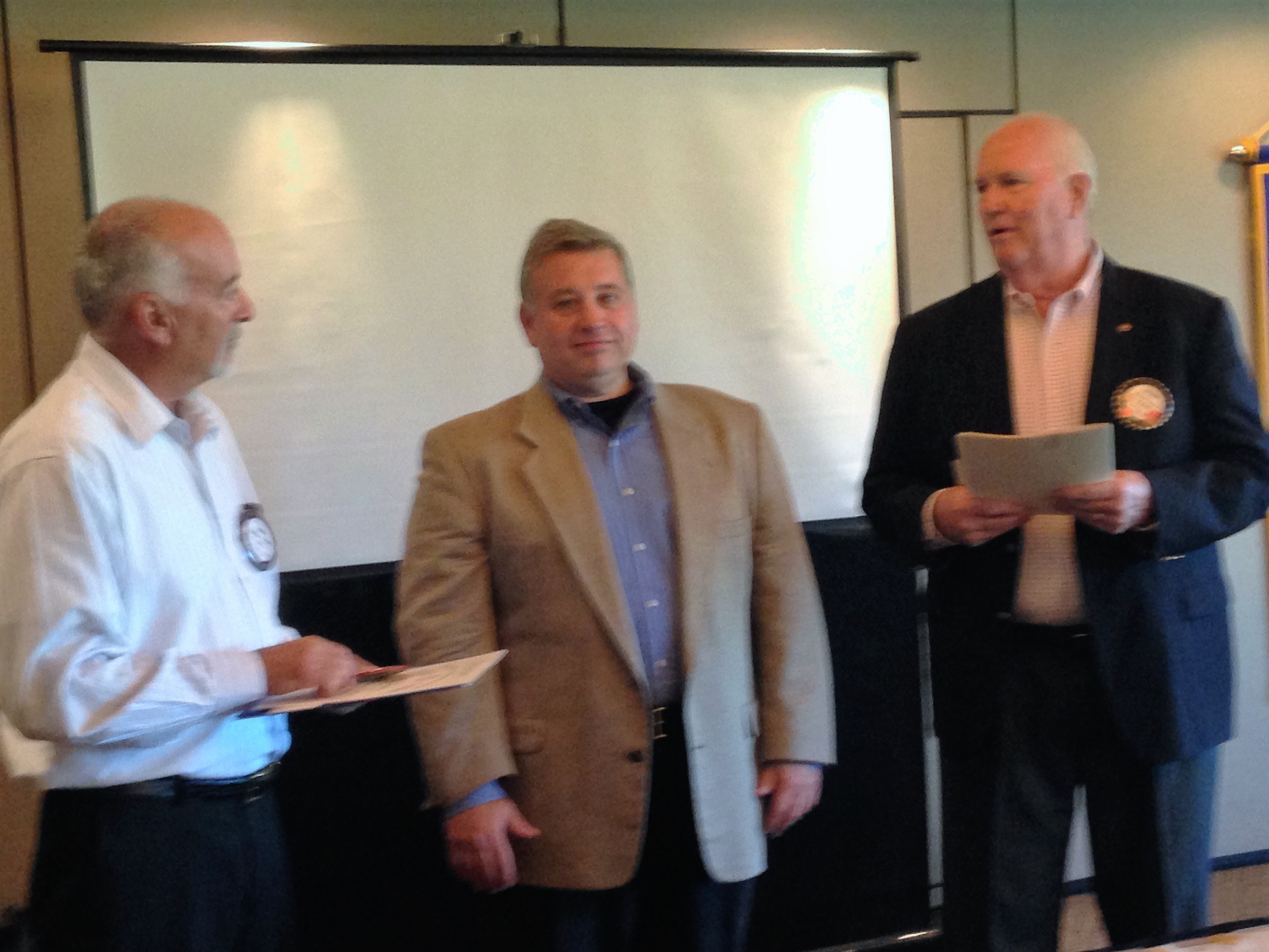 Bruce Barber (right) inducts Marc Ressler (center) into the Rotary Club as sponsor Vincent Grassia looks on.