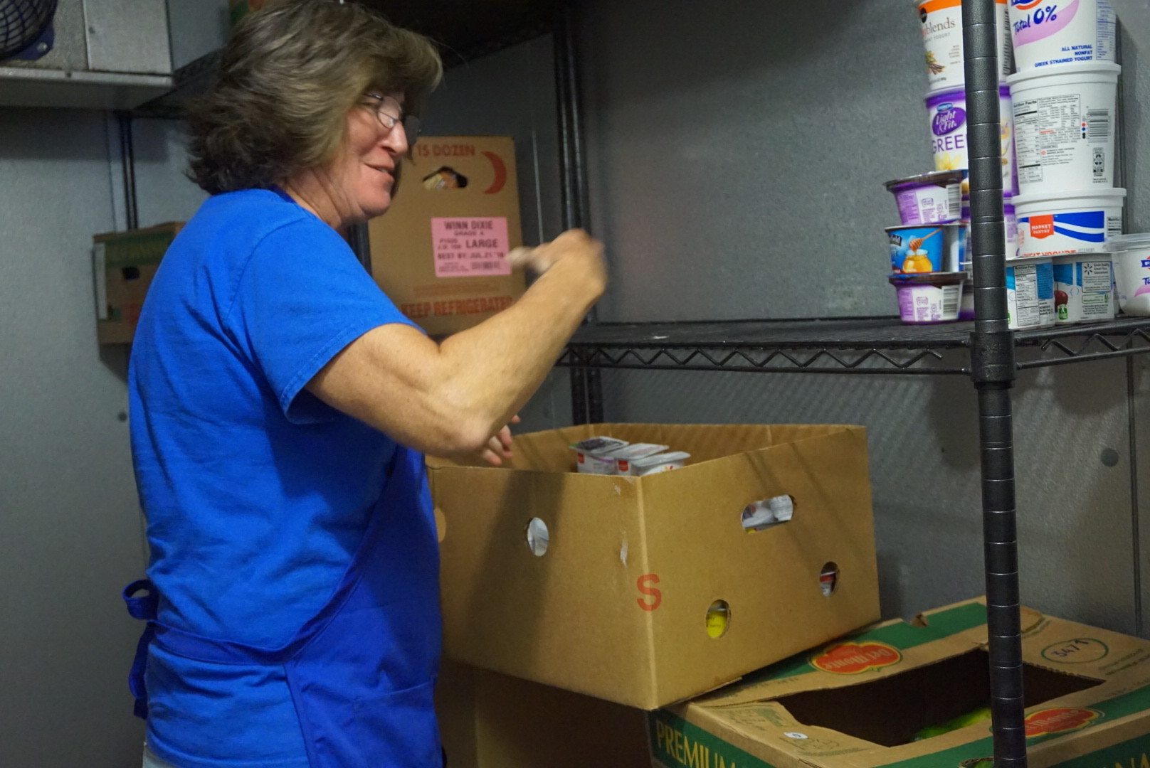A volunteer stocks the food pantry's meat freezer