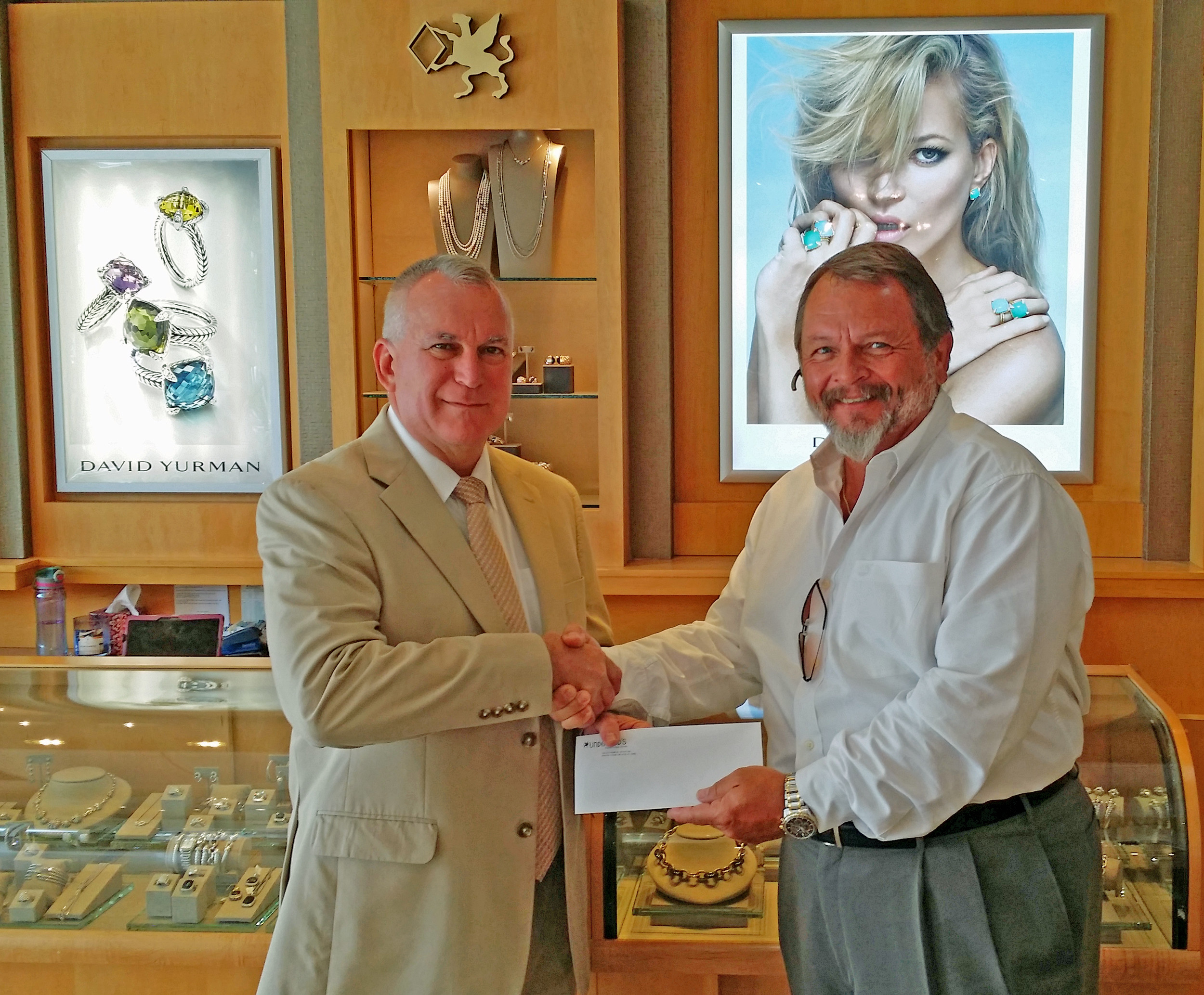 Underwood’s General Manager John Rutkowski presents a check to Haven Horse Ranch Executive Director Ric Lehman.