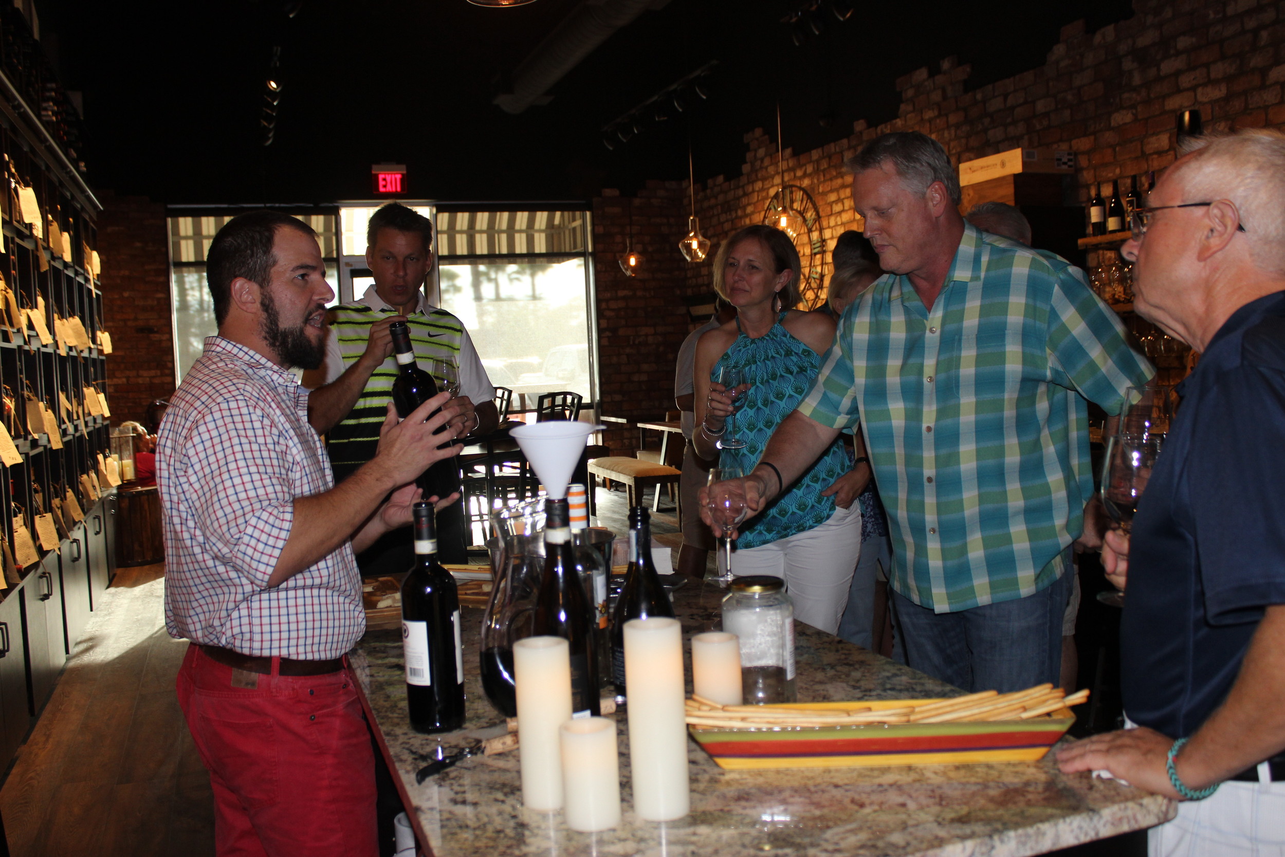 Coastal Wine Market Owner Steve Lourie pours wine for guests.