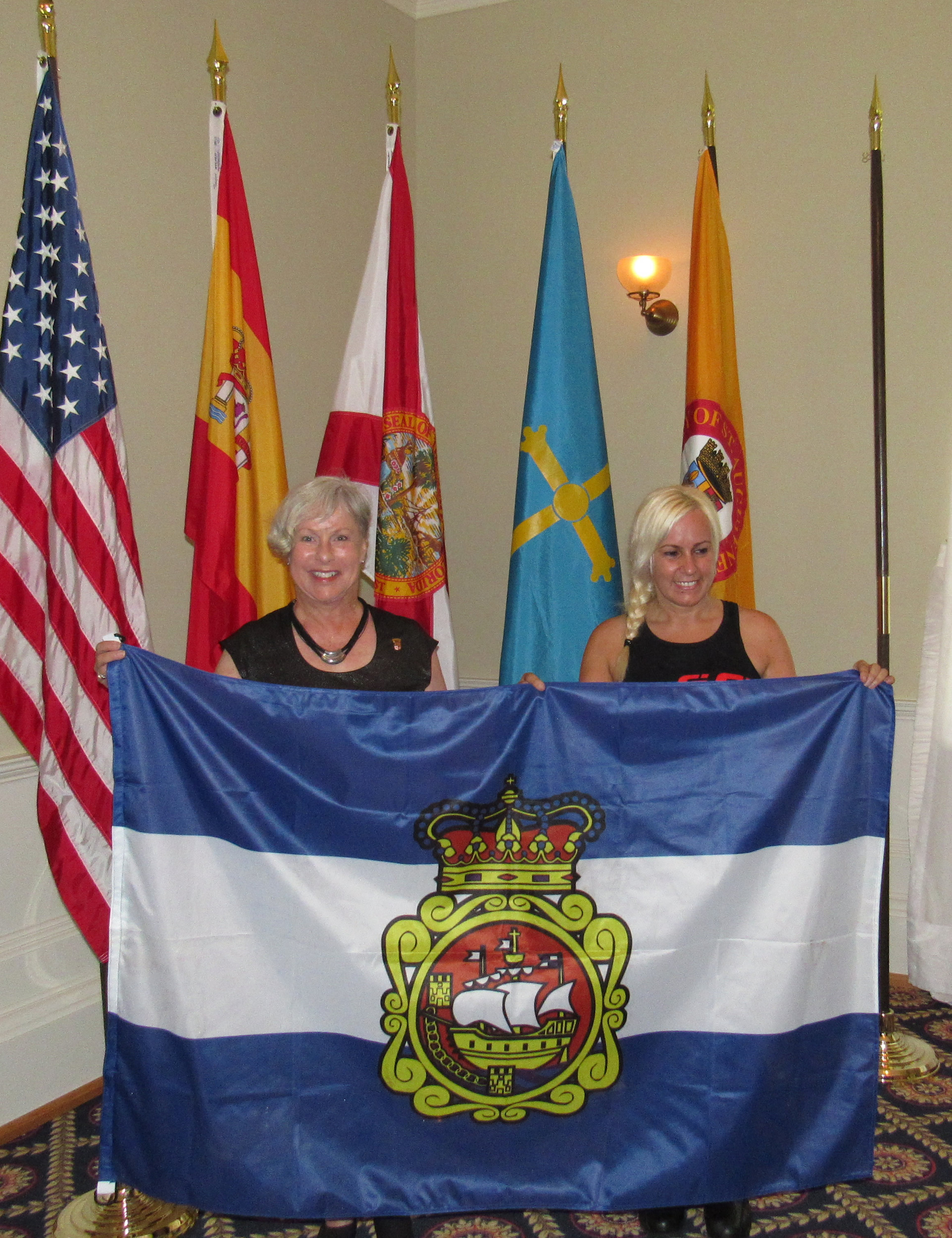 St. Augustine Mayor Nancy Shaver (left) and Sonia Barbosa of Aviles (right) hold the City of Aviles flag.