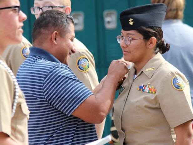 Navy Chief Petty Officer Jose Luna pins on the new rank to his daughter cadet Natalie Luna during the Nease NJROTC winter Promotions & Awards ceremony.