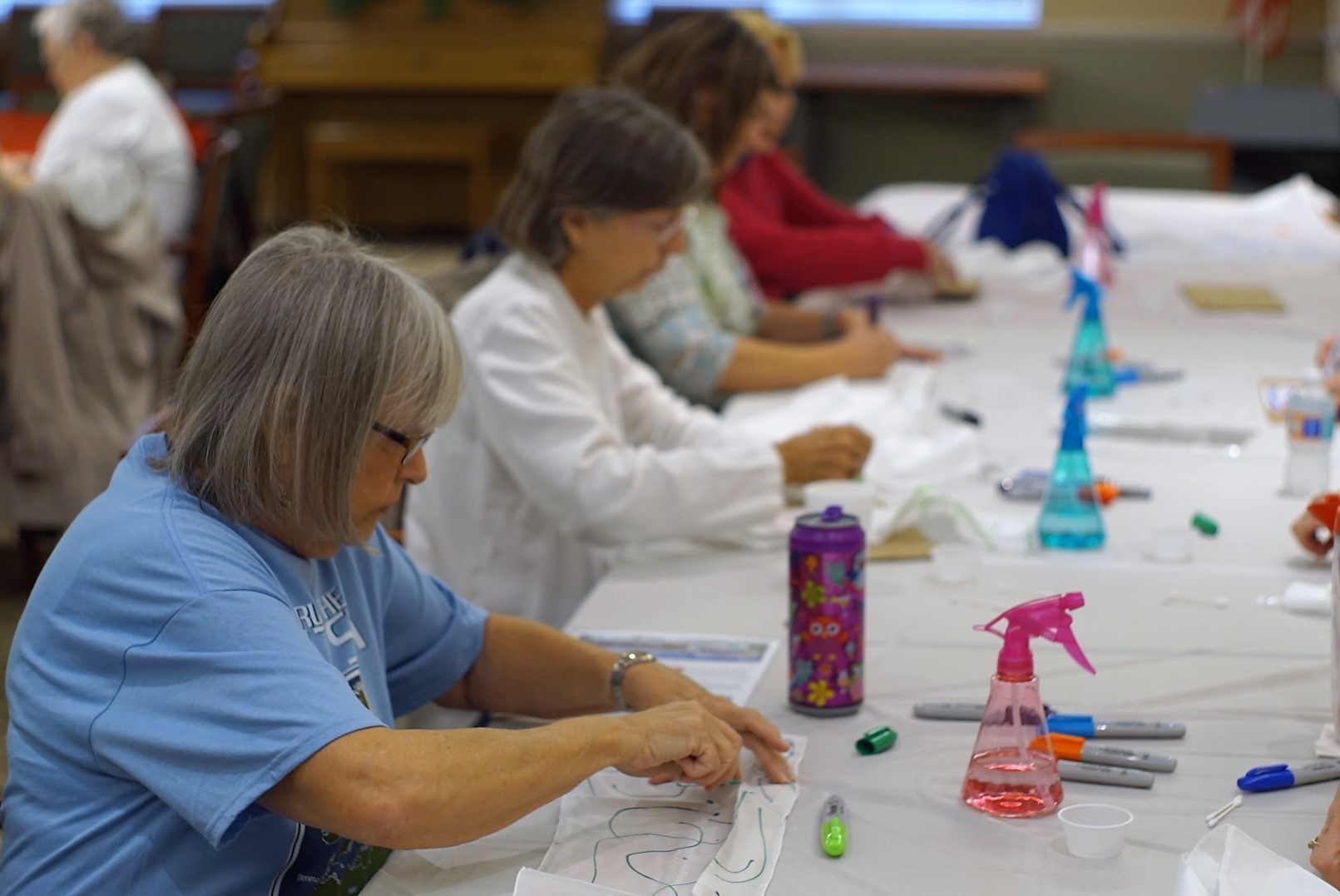Students doodle with their own sharpies during the silk scarf painting class.