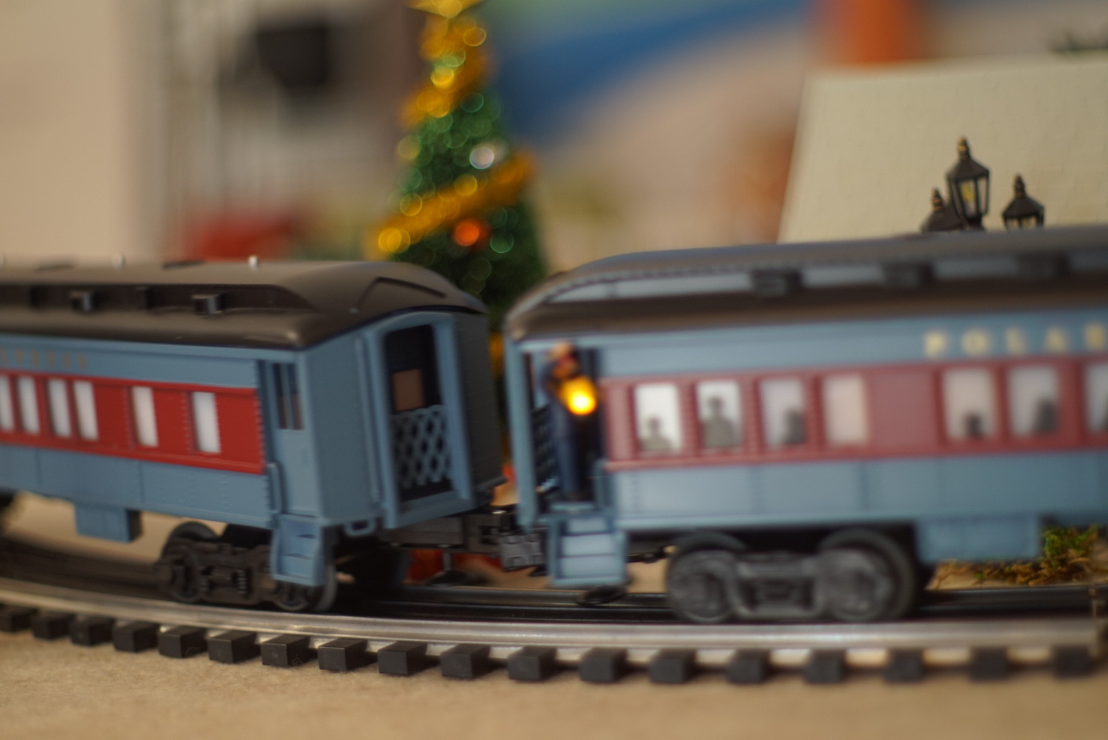 A miniature Polar Express zooms past Christmas trees and carolers