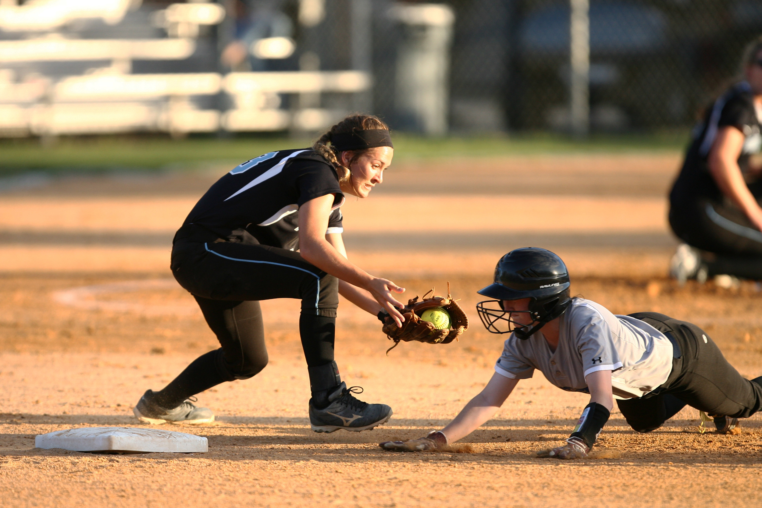 Shark second baseman Kiley Hennessey tries to tag the Ridgeview base runner, diving back to second on an infield hit. The umpire called the runner safe on the play.