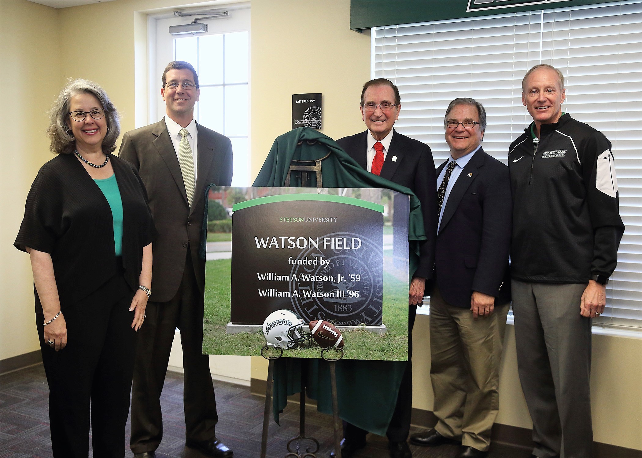 Stetson President Wendy B. Libby, Bill Watson III, William A. Watson, Jr., Stetson Athletics Director Jeff Altier and Stetson Head Football Coach Roger Hughes gather with a photo of the new field sign.