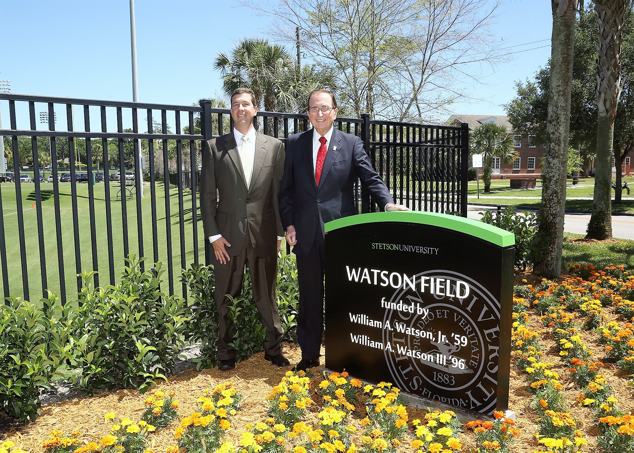 Bill Watson III and William A. Watson, Jr. stand in front of the new Watson Field sign at Stetson University.