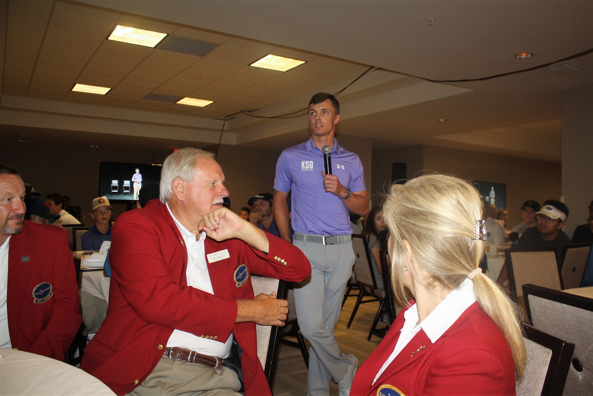 Members of THE PLAYERS Championship Red Coats volunteer leadership listen as Blayne Barber describes his experiences with FCA Golf.