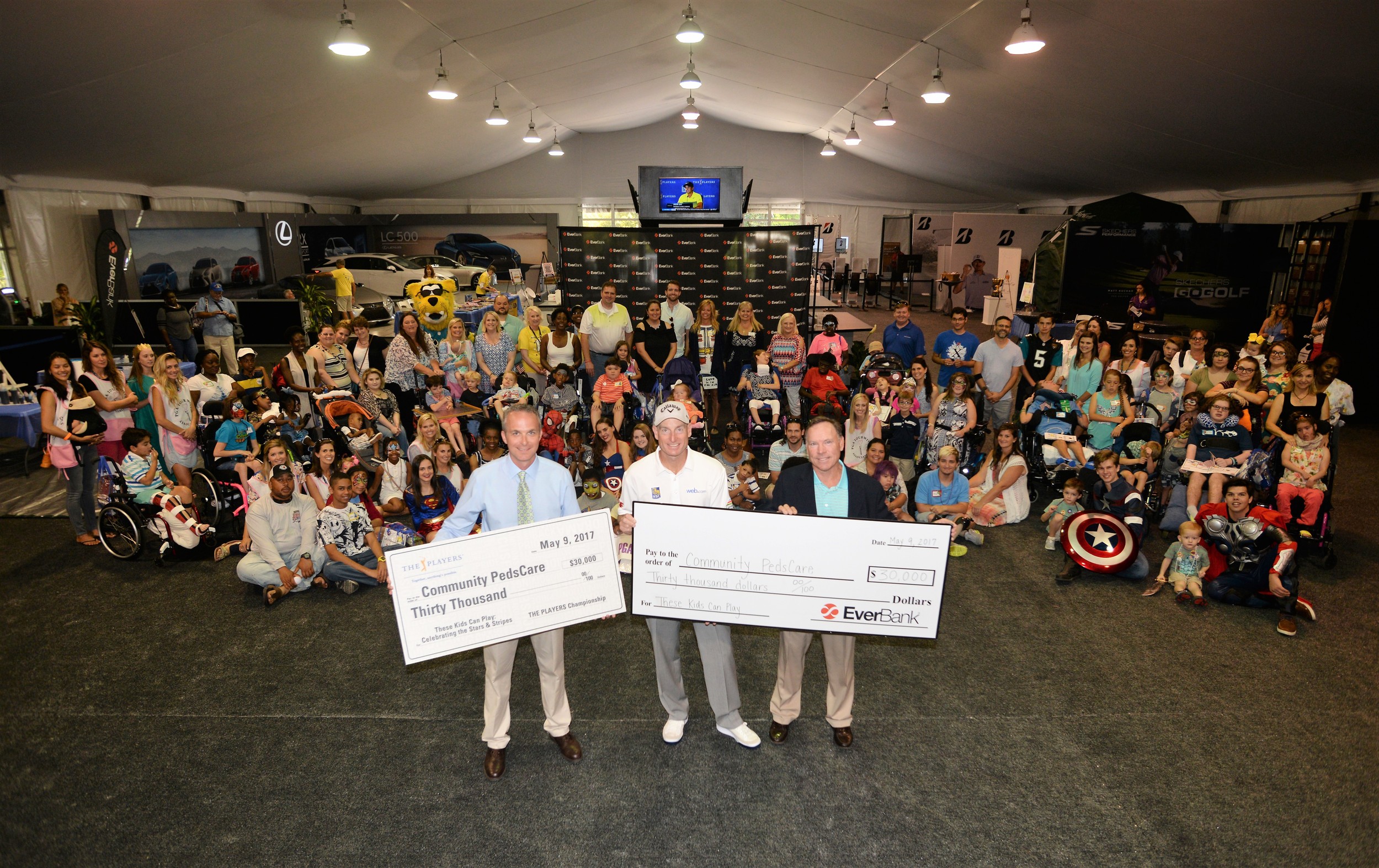 THE PLAYERS Championship Executive Director Jared Rice, PGA Tour player Jim Furyk and Everbank President of North Florida Banking Curt Cunkle display the donations to Community PedsCare.