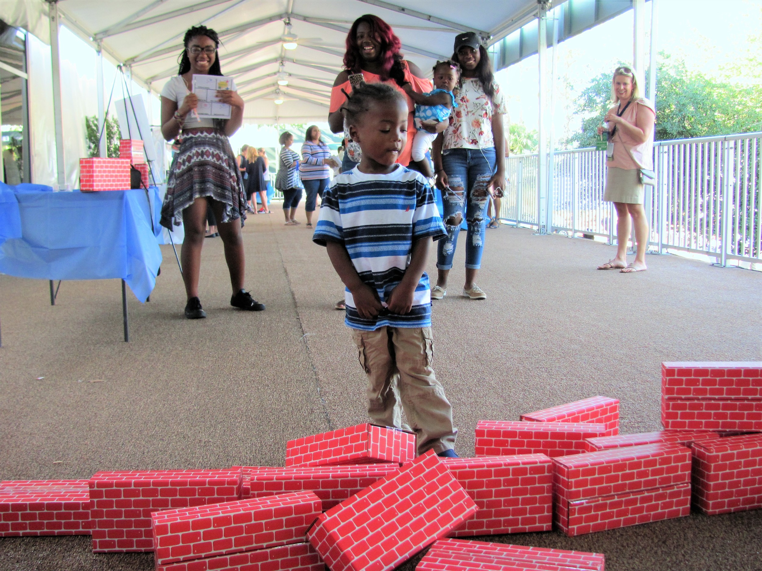 One of the children at the event kicks over a stack of blocks.