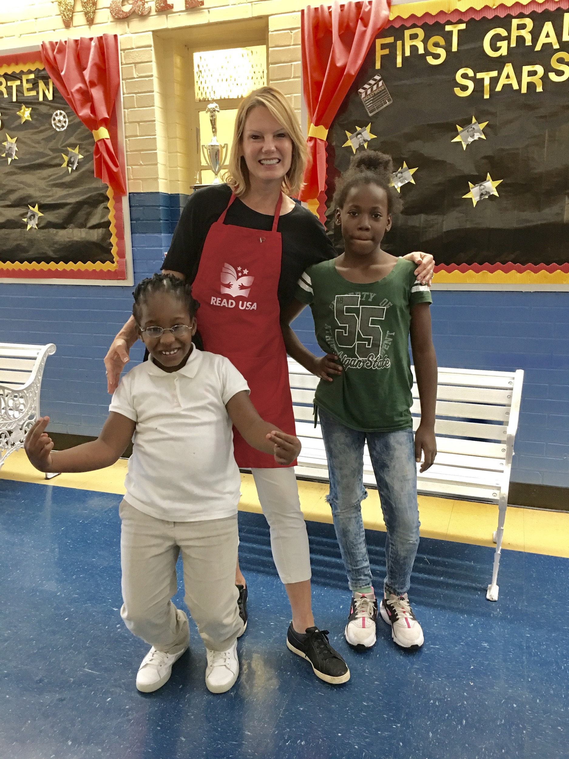 Ellen Wiss gathers with SP Livingston Elementary School students Amarciona Ferguson and Melia Mitchell at a Read USA book fair.