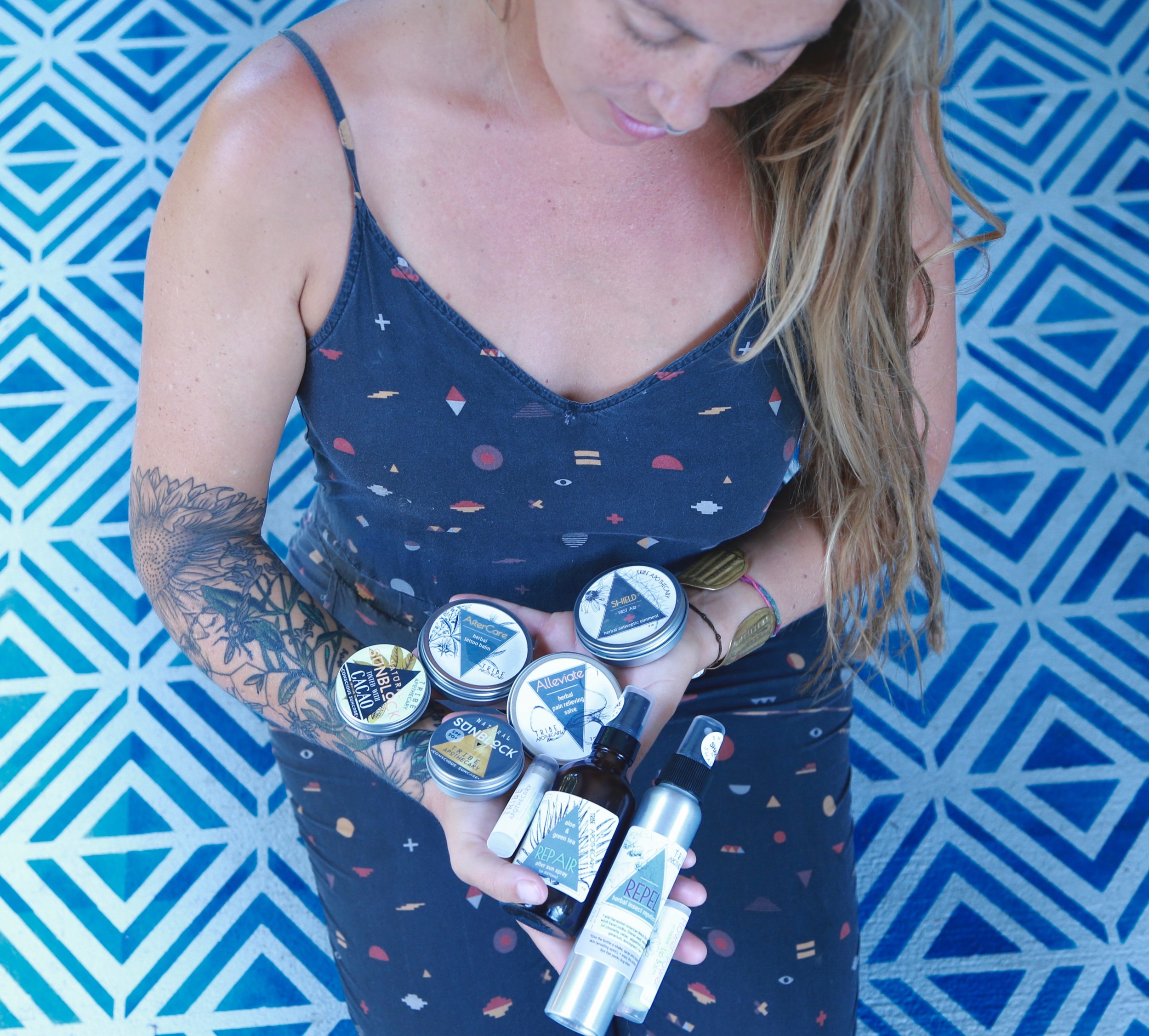 Tribe Apothecary owner Lauren Estes displays the various sunscreen and skin care products that her business sells.