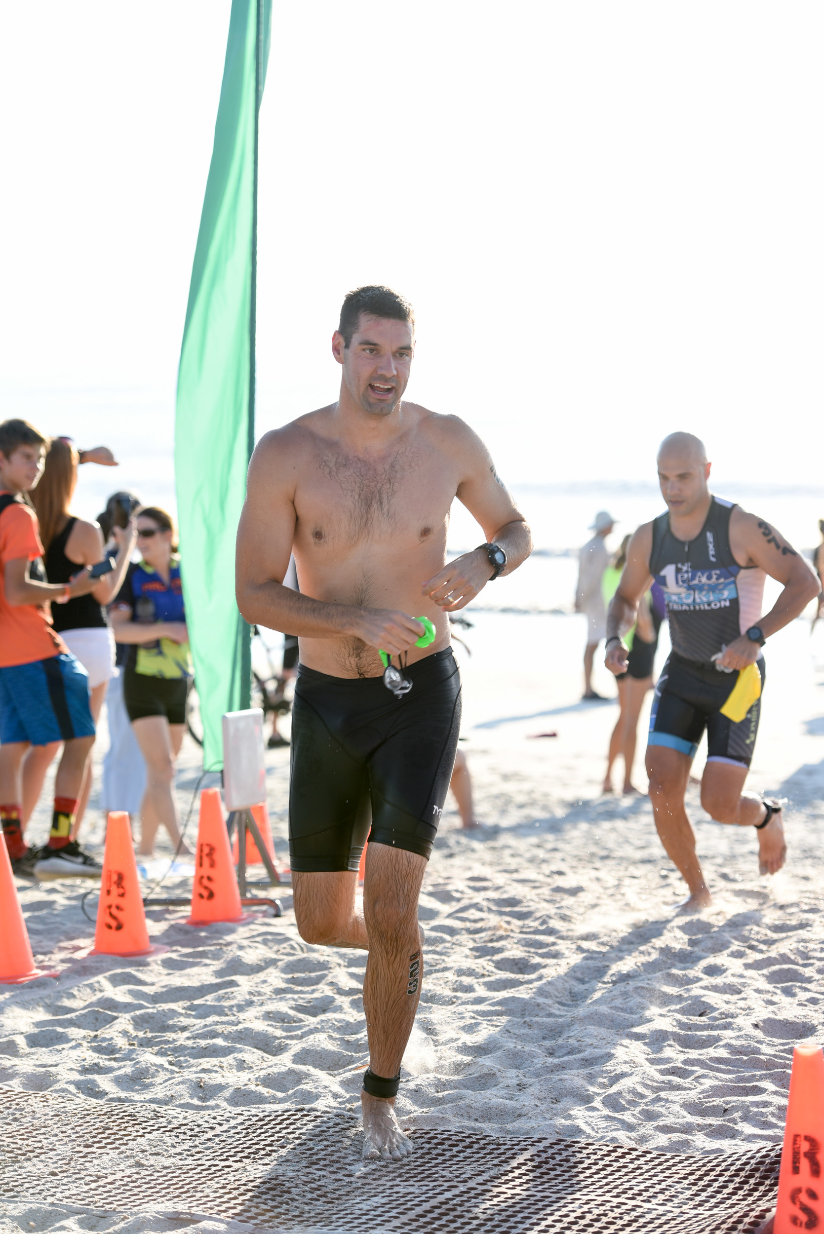 Triathlon participants exit the water at Mickler’s Beach