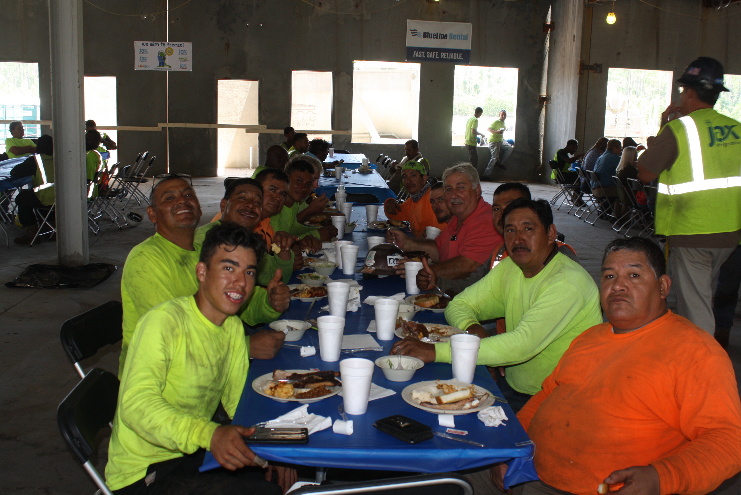 Contractors at the school construction site enjoy a barbecue lunch at the ceremony.