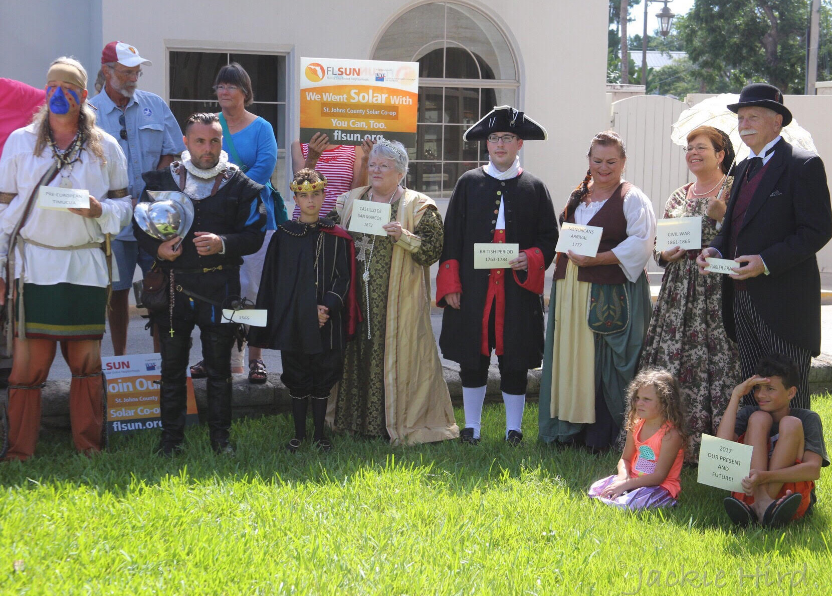 Historical re-enactors stand with signs at the solar cooperative launch event.
