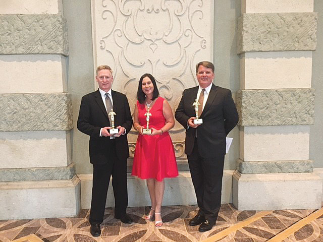 Walter O’Shea, Carla Luigs and Lane Gardner of Hines accept Aurora Award trophies at the Southeast Building Conference July 28 at the Gaylord Palms Resort and Conference Center in Kissimmee, Florida.