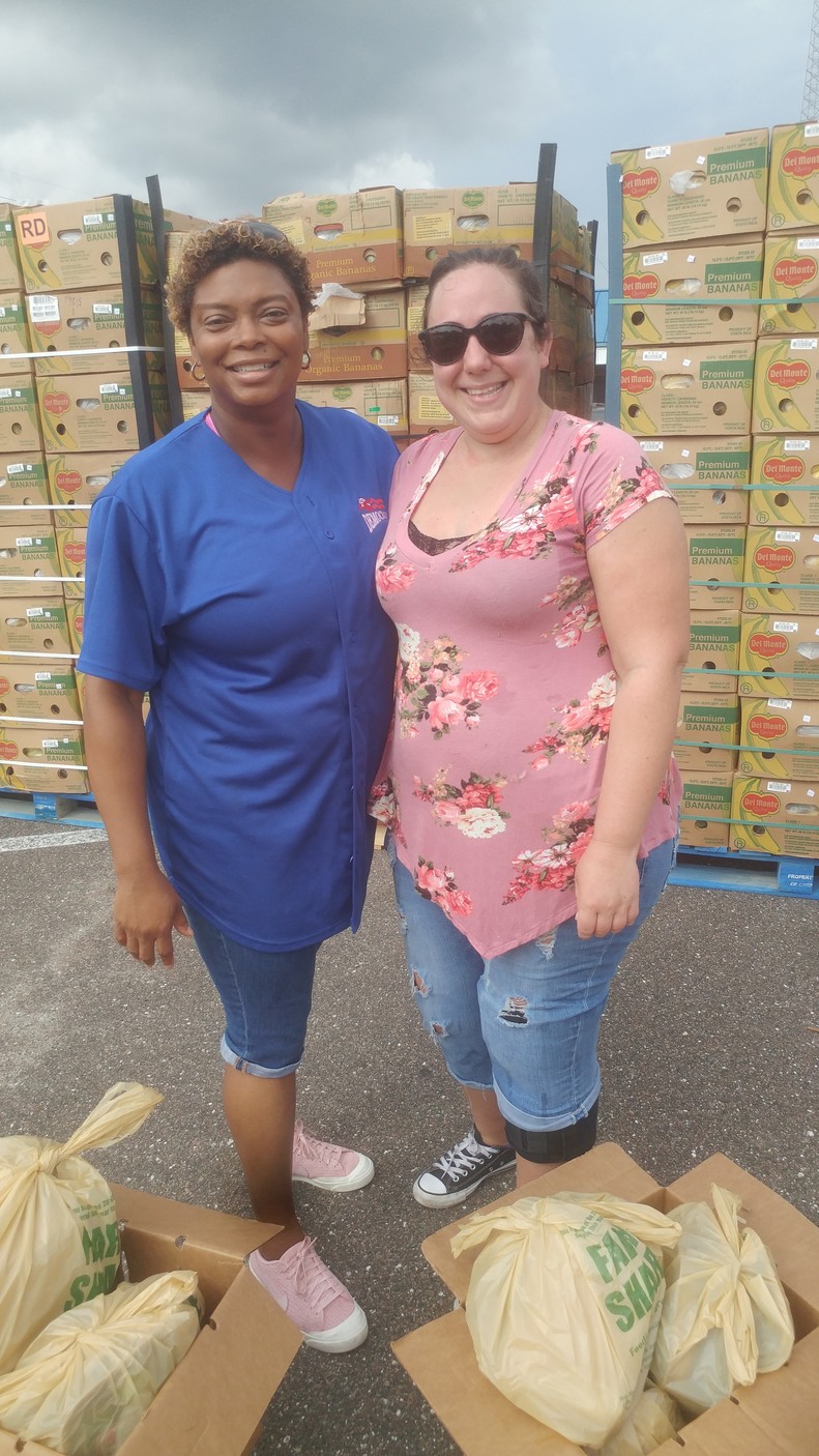 Rep. Tracie Davis (left) lends a helping hand at Farm Share’s Sept. 16 community distribution event.