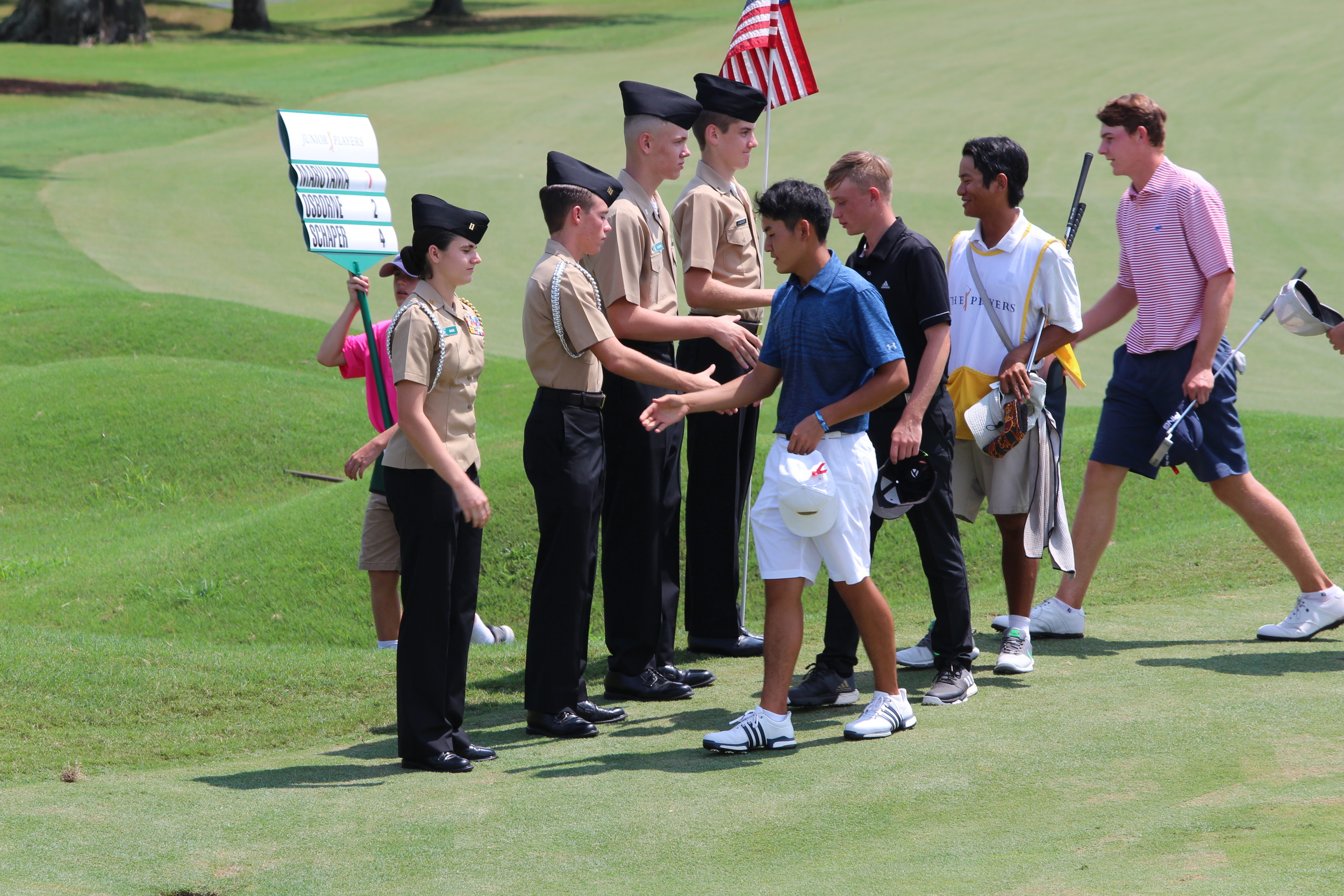 Nease NJROTC cadets Erin Sass (from left), Troy Barber, Will Moore and Ryan Landeweer participate in the No. 18 hole pin tending during the final round of the Junior PLAYERS Championship on Sept. 3, at THE PLAYERS Stadium Course at TPC Sawgrass.