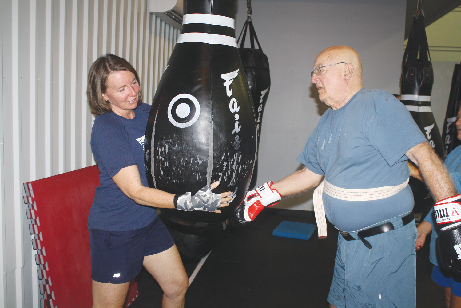 Kristen Gray (left) guides a “fighter” through a boxing routine during a training session.