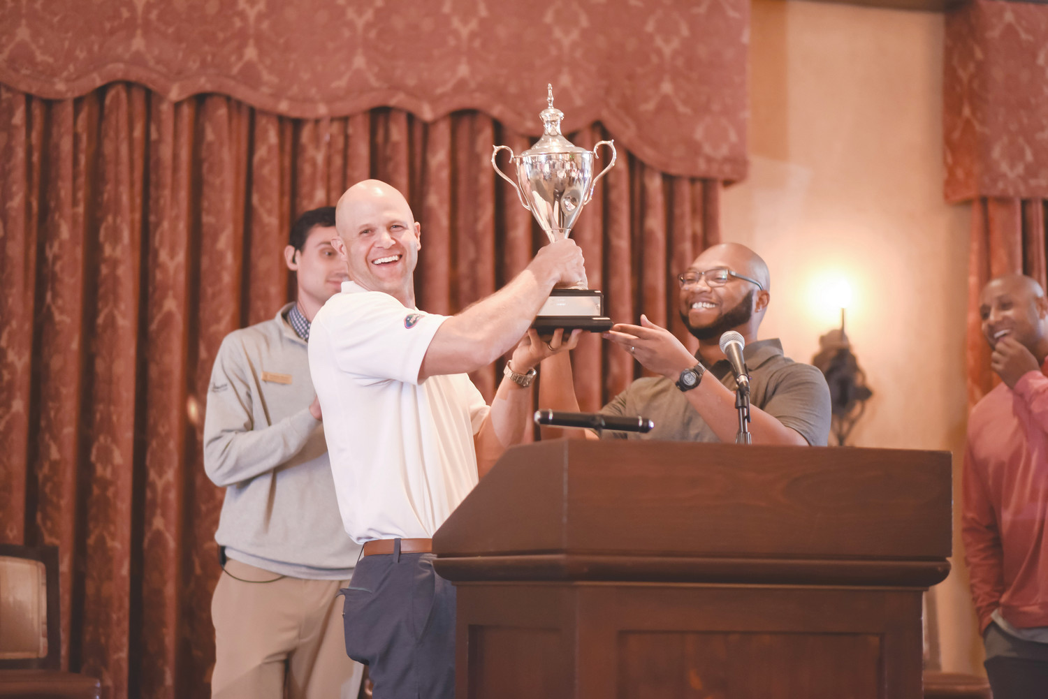 Danny Wuerffel and Demetrius Summerville, executive director of Kaley Square in Orlando (Desire Street Ministry partner), award the Desire Cup to the Florida Gators golfers, who won the tournament 32-30.