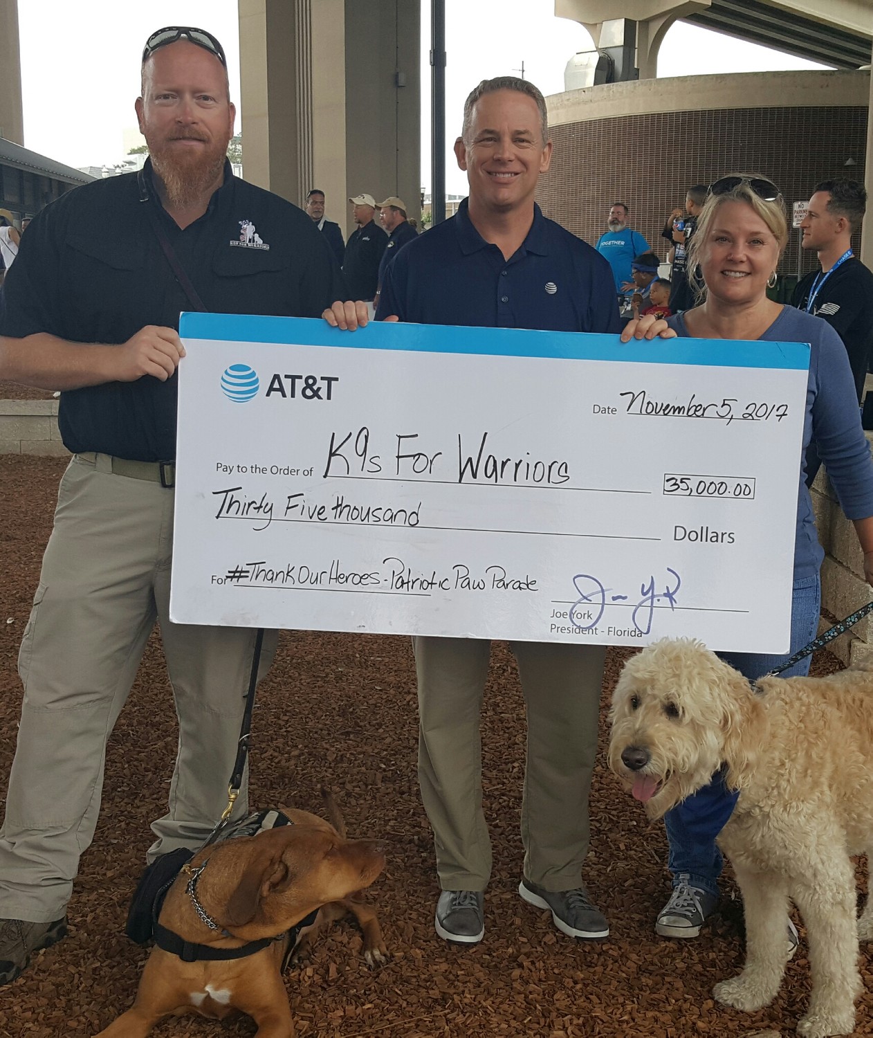 Greg Wells and Utah (left) receive a $35,000 check on behalf of K9s For Warriors from Joe York and Heather Duncan of AT&T. The company has partnered with the Ponte Vedra nonprofit as part of its Thank Our Heroes campaign. The $35,000 donation is part of a $500,000 contribution from AT&T to veterans organizations across the country.