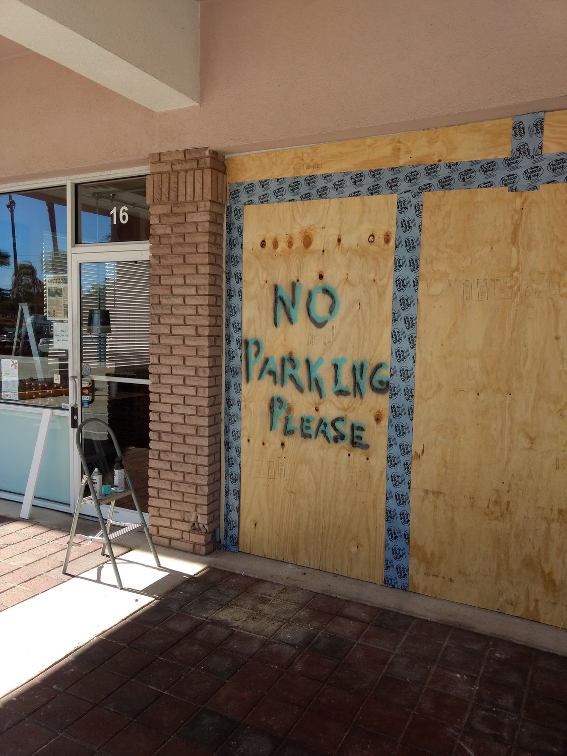 The boarded-up front window of Down South Barbecue requests that drivers refrain from parking in the store.