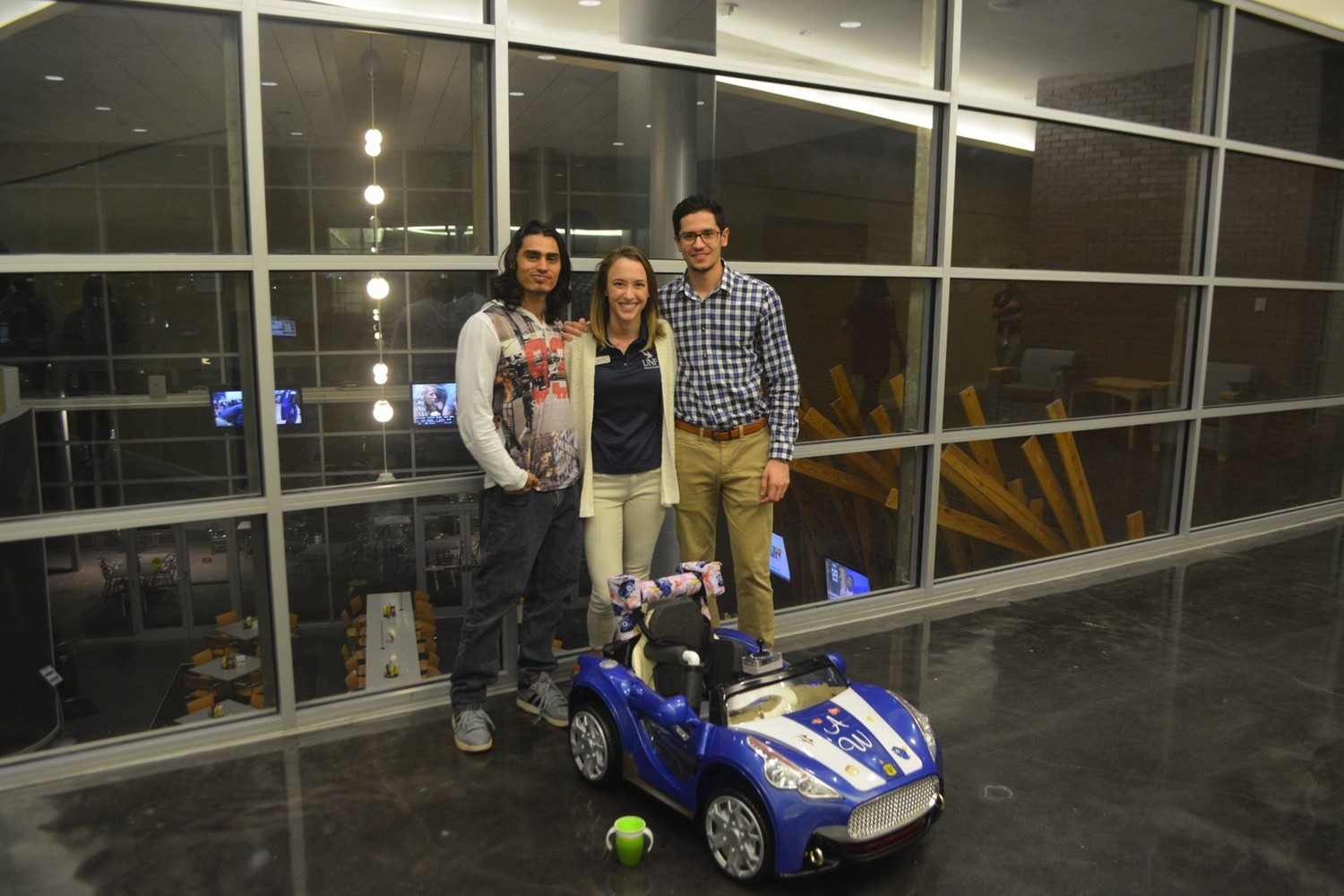 Husam Safar (right) poses for a picture with his teammates, behind their toy car creation.