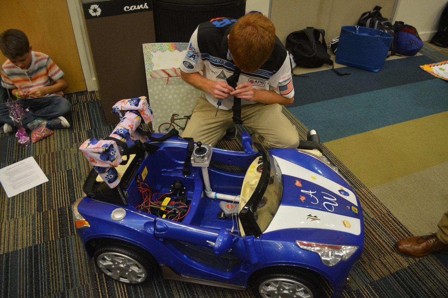 A UNF student does some last-minute adjustments to a toy car.