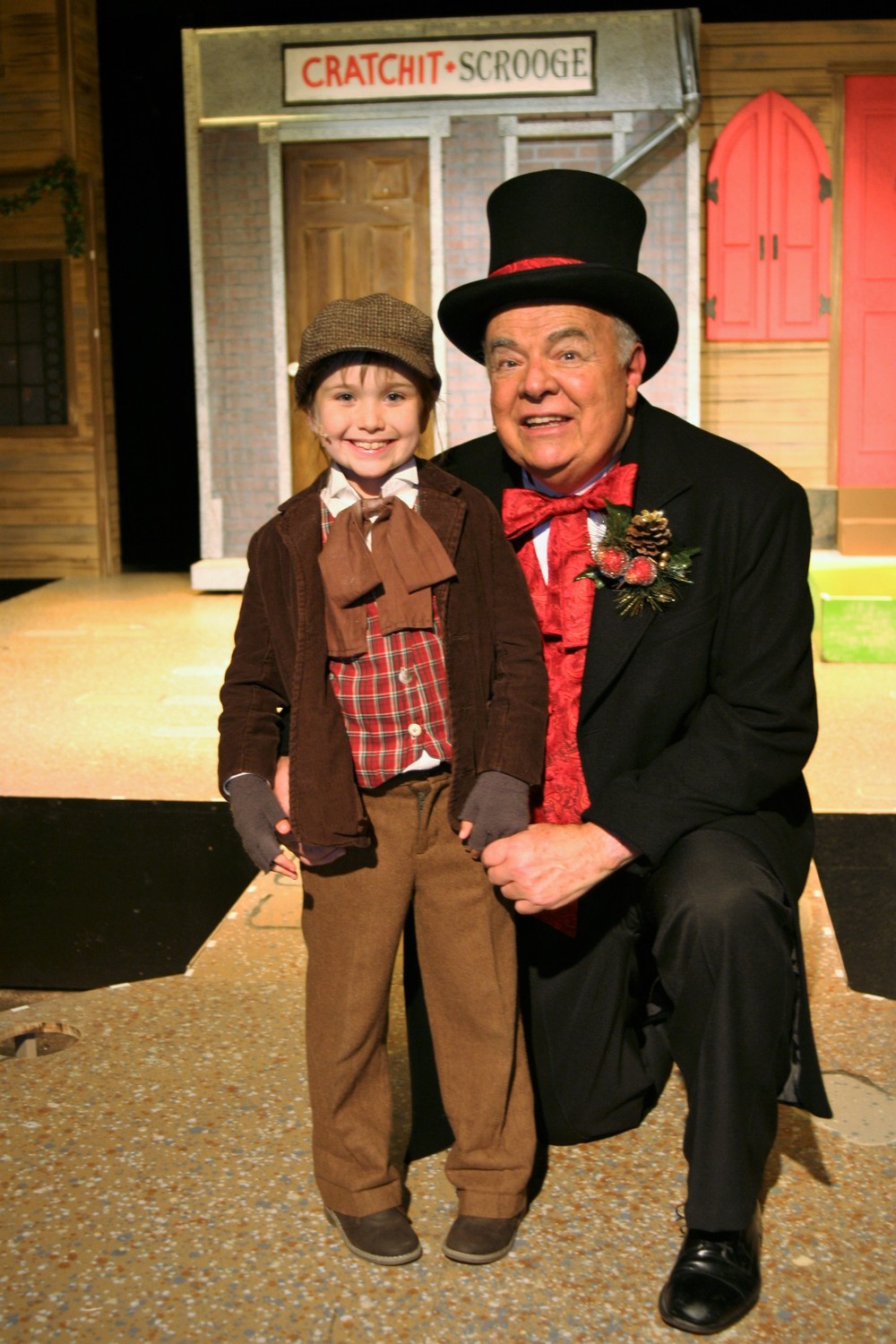 In the Alhambra production of “Christmas Carole,” Ebenezer Scrooge is portrayed by director Tod Booth (right), and Lucy Feagins is Tiny Tim.