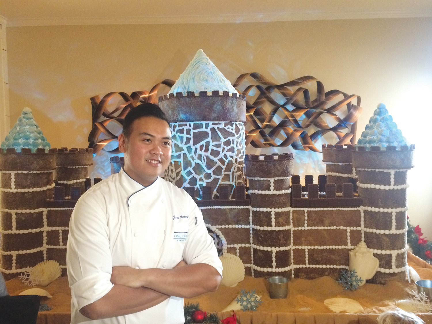 A One Ocean Resort & Spa employee poses for photos in front of the gingerbread castle.