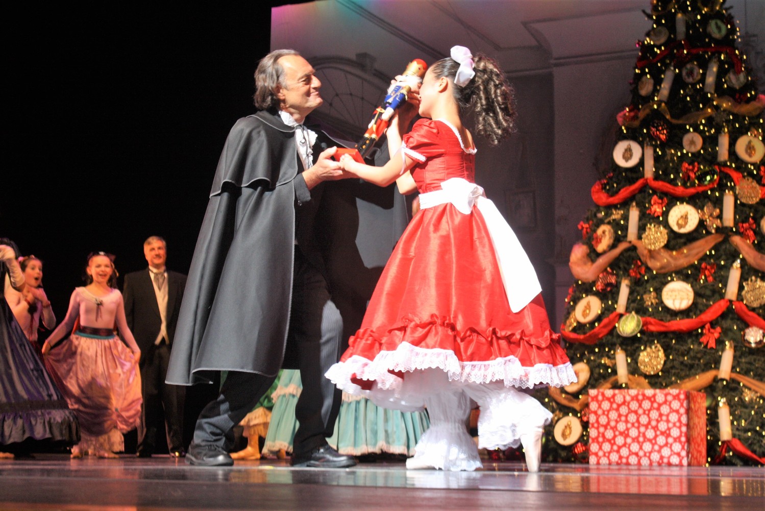 Clara, portrayed by Ellie McCary, receives a nutcracker doll from her Uncle Drosselmeyer, played by Anthony Egeln Sr.