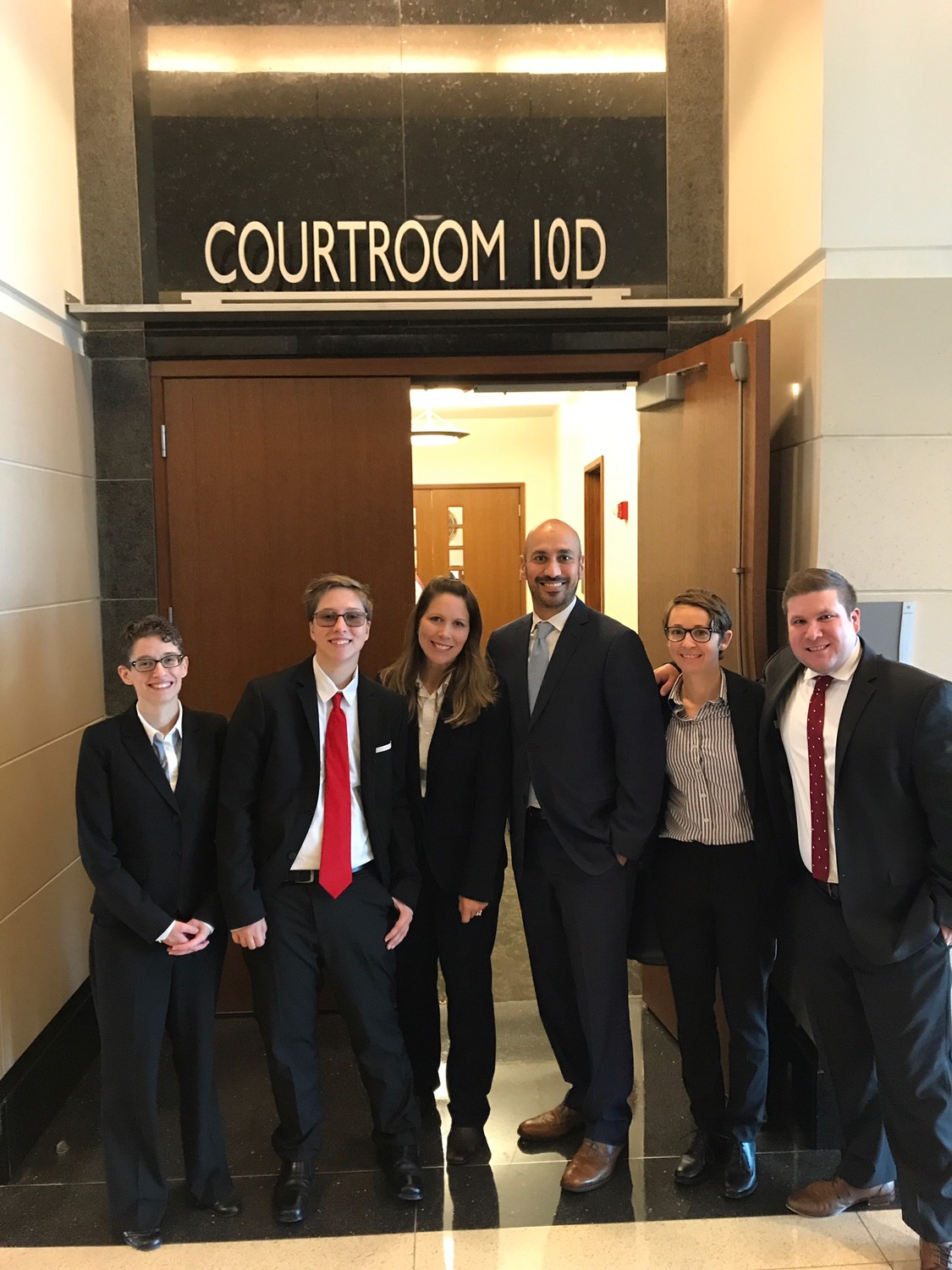Drew Adams (second from left) and his mother Erica Kasper (third from left) gather with the Lambda Legal attorneys during last week’s federal trial in Jacksonville.