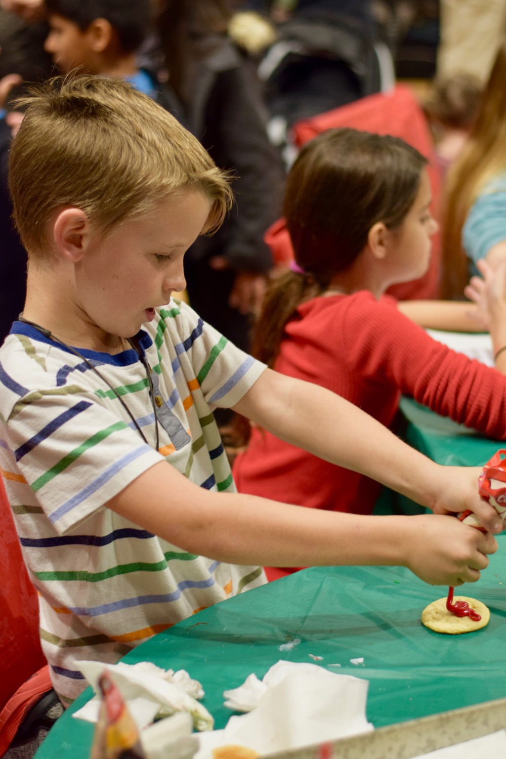 Children celebrate the holidays by decorating cookies at Shearwater’s Winter Festival.