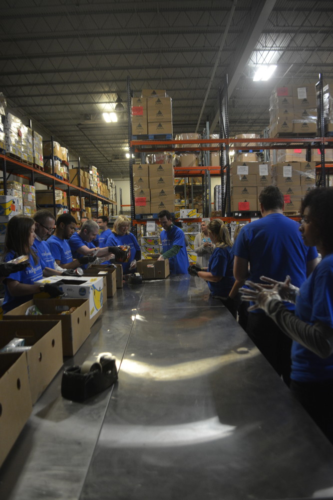 Volunteers work quickly to organize food for families in need.