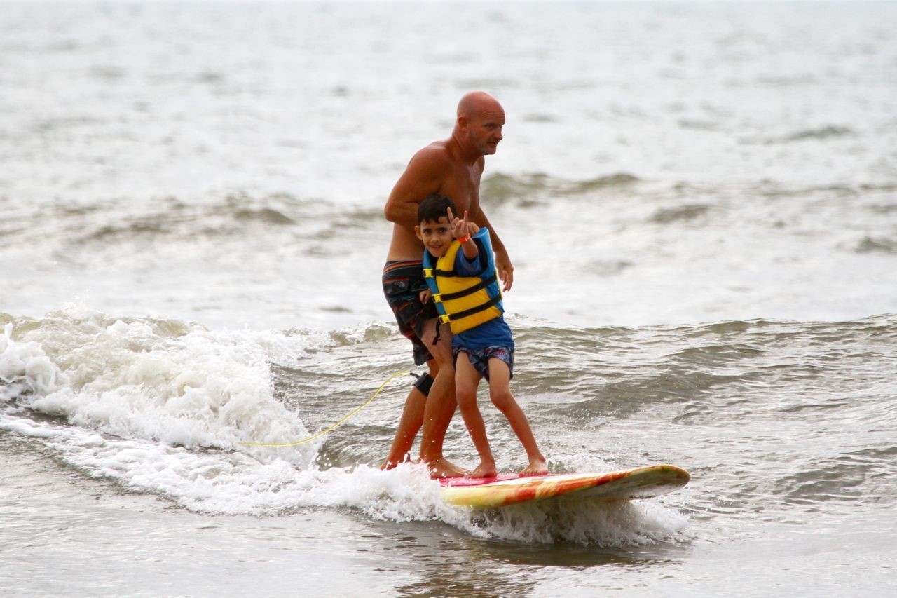 A boy with autism learns to surf at HEAL’s Riding the Wave of Autism surf camp.