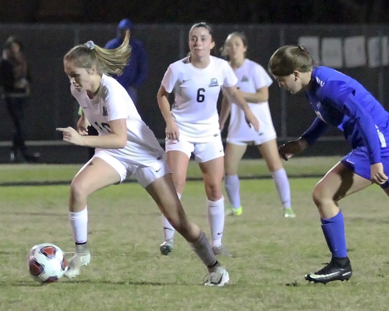 The Sharks’ Kai Hayes races past the Pedro defender as Molly Miller looks on.