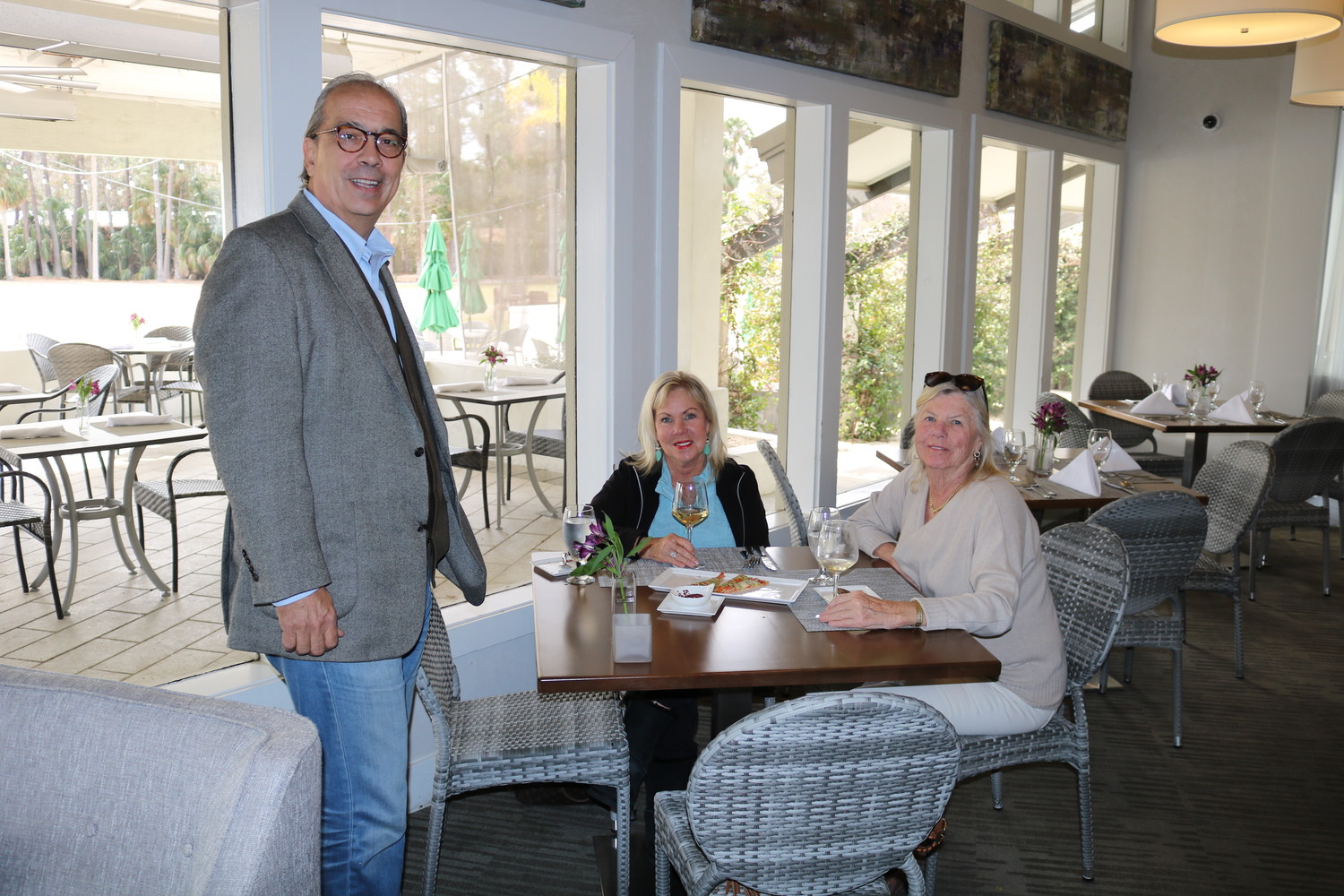 Bernard de Raad poses for a photo with customers enjoying lunch at 3 Palms Grille.