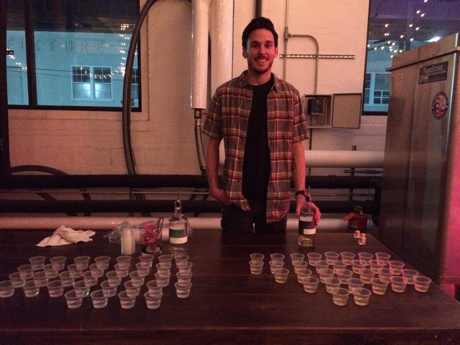 Ian Mikrut poses for a photo behind drinks for Bowtie Ball guests at Manifest Distilling in Jacksonville.