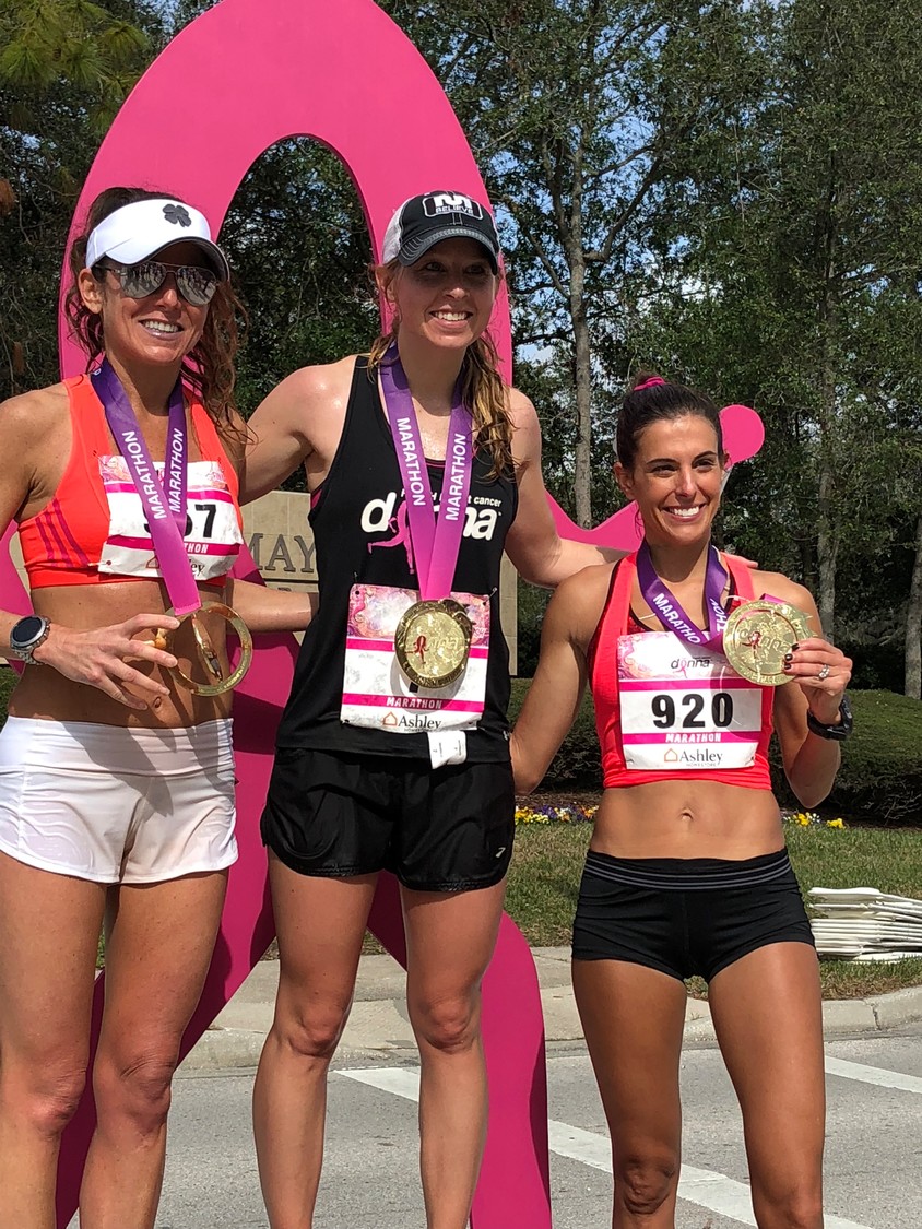Three runners pose with their medals.