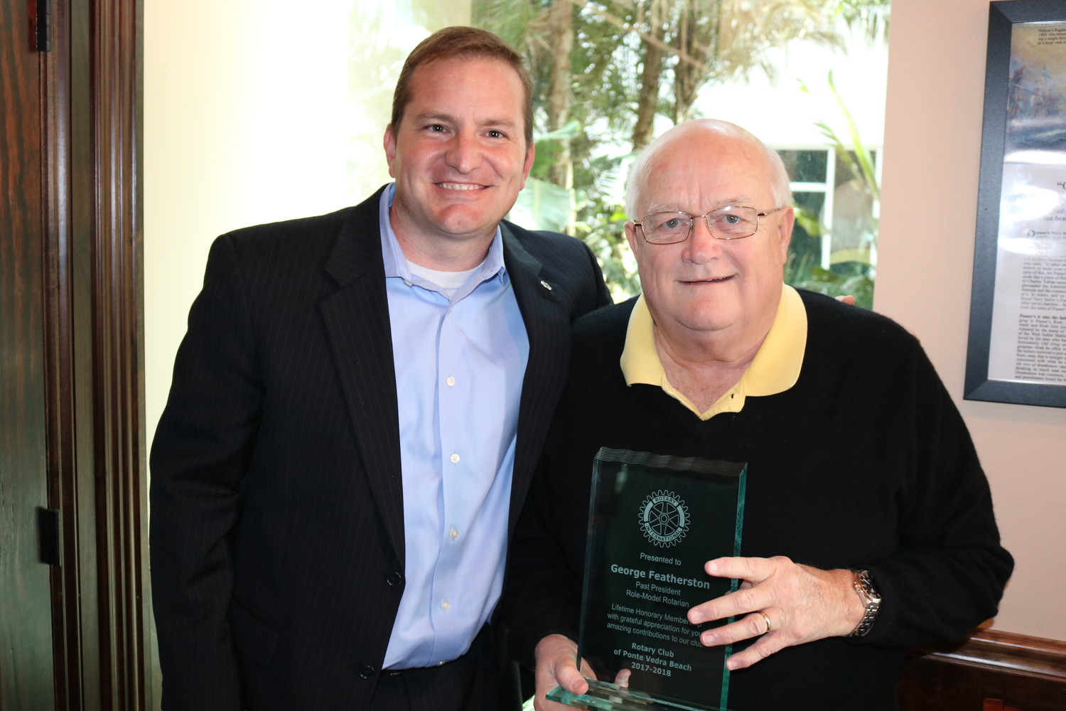 Rotary Club of Ponte Vedra Beach President Billy Wagner (left) presents an honorary membership plaque to longtime club member and past president George Fetherston (right).
